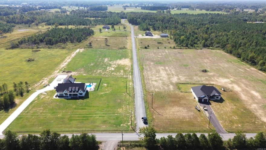 Beautiful flat 6.30+/- acre lot right outside of city limits, perfect spot if you are looking to build! Gorgeous new construction houses are going in all around. Enjoy great views of the countryside in a quiet area while only being a few minutes from the interstate. 20 mins to Vilonia, 20 mins to Searcy, & 20 mins to Cabot. Water and electric are available at the road. No mobile homes. Minimum square footage of 1700.