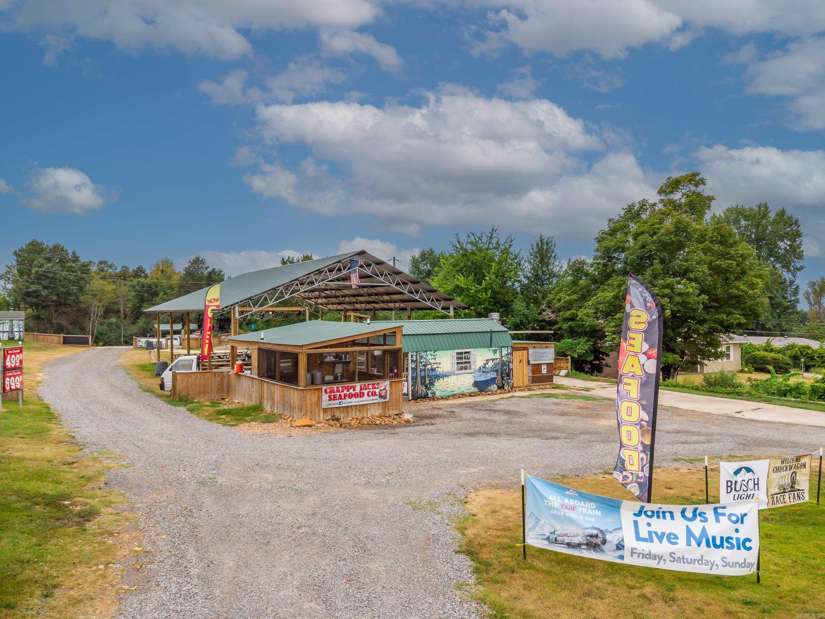 Here is your chance to own a thriving & fun outdoor restaurant. This seafood restaurant is in a high visibility location & has a coastal feel. It features partially open cooking stations where customers can watch fresh seafood being prepared, a covered eating area with wooden tables (160 seats), string lights & umbrellas. There is a large stage where live music, or the DJ booth w/ sound equipment, can be heard but not overpower conversations. This established restaurant is well loved by the community & used for reunions, family gatherings or just a fun night out. All buildings, equipment, recipes & food/inventory contacts included. See agent remarks for more details.