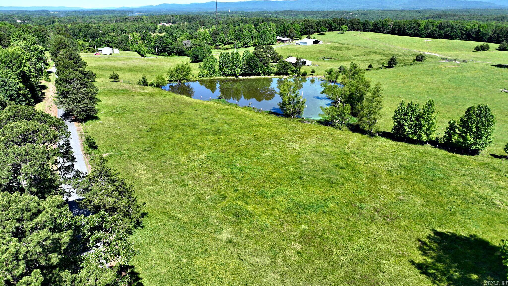 Welcome to 12 beautiful acres of gently rolling pastureland—an ideal setting for your dream homestead. This picturesque property features a solid steel truss barn with stalls, perfect for livestock or storage, and offers plenty of open space for gardening, grazing, or building your future home. A large spring-fed pond, stocked with catfish, creates a peaceful and scenic centerpiece, while a smaller spring-fed minnow pond adds to the charm. With paved road frontage on two sides and sweeping views of the surrounding countryside, this property offers a rare combination of functionality and natural beauty. Whether you're looking to start a hobby farm or simply enjoy quiet country living, this land is ready to bring your vision to life. Taxes are estimated for entry. Property will have to be assessed as it's own parcel and acreage is estimated. Rural Water and electric available.
