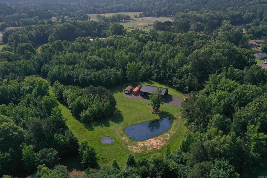 If you are looking for a property that combines the convenience of town, but the privacy and recreation of country living, this property is the one for you! Located at the dead end of East 12th street, this 17 +/- Acre property is as convenient as they come, and is a part of one of the best neighborhoods in town. Entering the property, a nice gravel drive extends from the city street to the 40x60 Pole Barn with three bay doors, which is well built and could easily be completely enclosed for a shop building. Two stocked ponds on the property provide great fishing opportunity, and would make a beautiful back yard setting. Mature Oak trees line the perimeter and dot the landscape on the property, providing an element of seclusion as well as great habitat for the wildlife that frequents the property. All of these wild areas can be easily accessed by the ATV trails that meander through the property. There is a buildable lot at the end of 12th street, as well as build sites close to the shop. The shop and area around it have had material hauled in and leveled to raise the elevation out of the flood plain.