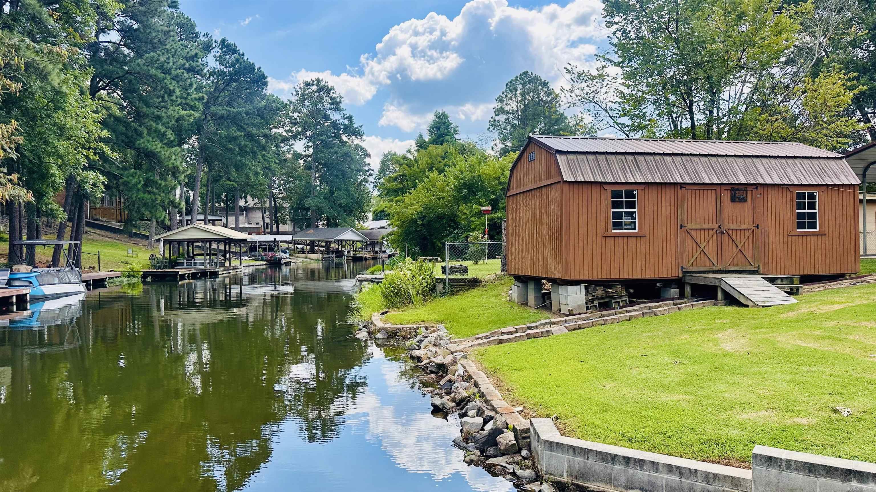 Affordable, Well-Maintained Lake Home with Boat Slip! Tucked away in a serene cove, this 2018-built 3-bedroom, 2-bath home is move-in readyājust bring your boat and fishing poles! With an open floor plan and ample parking, it's perfect for weekend getaways or entertaining friends and family. Enjoy peace of mind knowing your boat is protected year-round with a detached carport, and keep your gear organized in the spacious 12x24 storage shed. Whether you're looking for a full-time residence or a vacation retreat, this property offers the ideal lake lifestyle. All offers will receive a counter at minimum. Move in just in time for the heart of summer and discover why so many are choosing to call Hot Springs home.