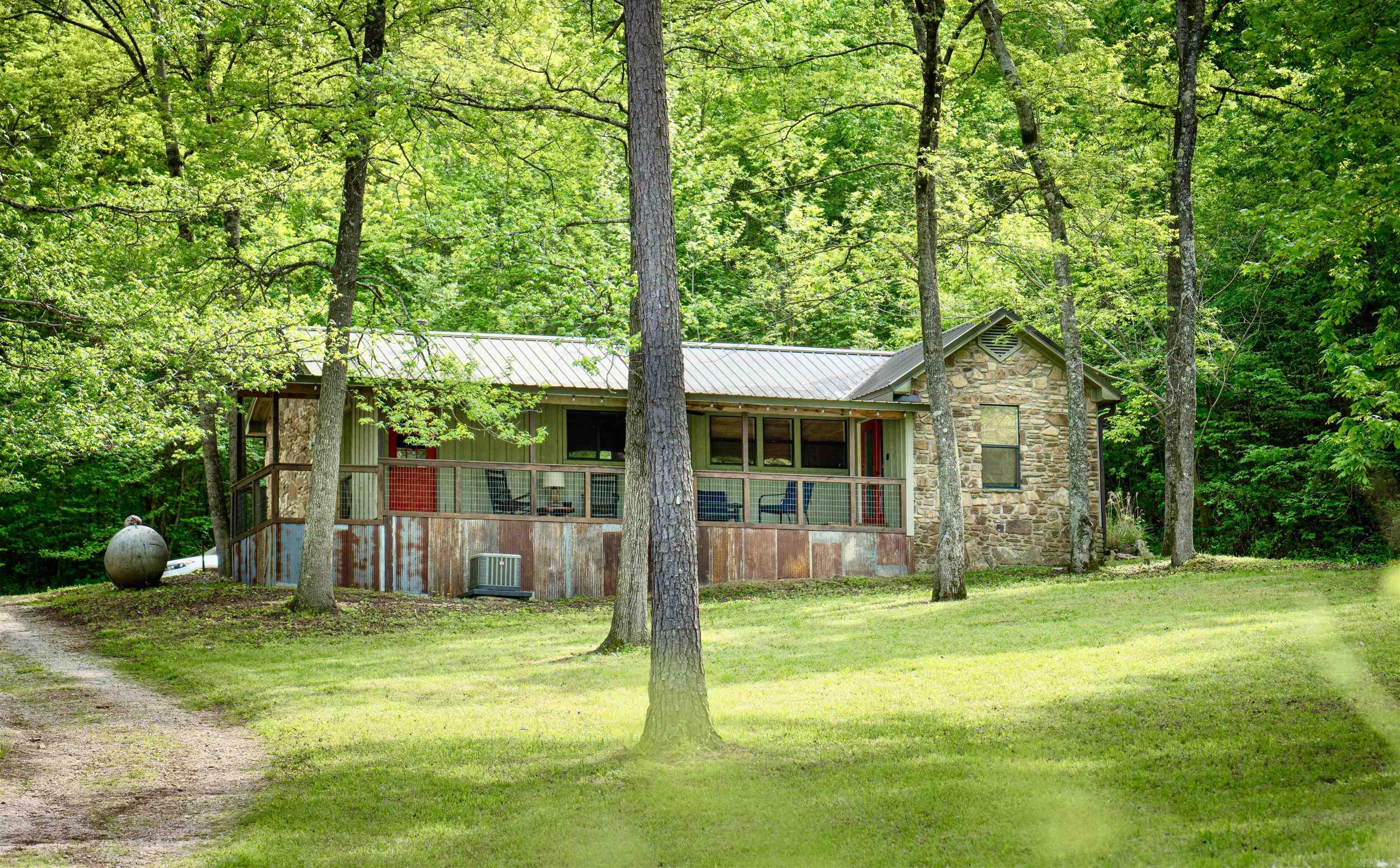 Sylamore Creek Retreat is a Fully furnished cabin tucked away under the shade trees in the Ozark Mountains with gorgeous views of the creek from the covered porch. This 1 bedroom, 1 bath home is currently a successful vacation rental! The cabin is tastefully decorated featuring an open floor plan with beautiful vaulted wood ceilings and a cozy wood burning fireplace. The property is very private with a large fenced in yard, storage building, and firepit area. NEW ROOF installed in 2024! Call to make this cabin yours!