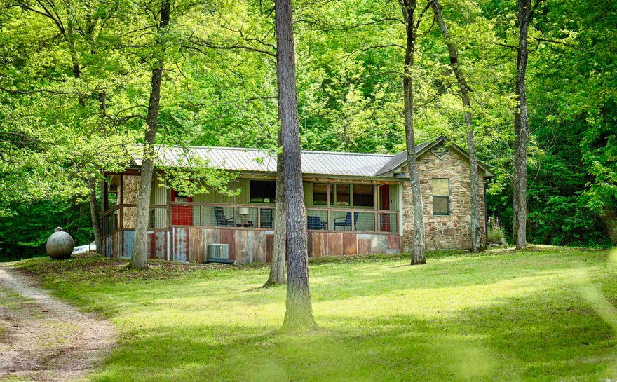 Sylamore Creek Retreat is a Fully furnished cabin tucked away under the shade trees in the Ozark Mountains with gorgeous views of the creek from the covered porch. This 1 bedroom, 1 bath home is currently a successful vacation rental! The cabin is tastefully decorated featuring an open floor plan with beautiful vaulted wood ceilings and a cozy wood burning fireplace. The property is very private with a large fenced in yard, storage building, and firepit area. NEW ROOF installed in 2024!  Call to make this cabin yours!