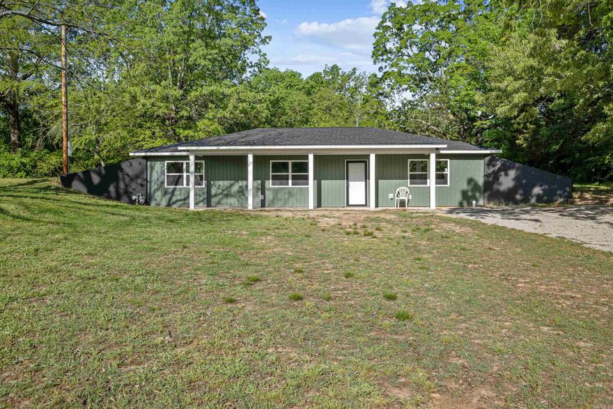 Words cannot fully capture the beauty of this stunning home; it truly must be seen to be believed, even more impressive than the photos suggest. Nestled on a hillside, this remarkable underground residence welcomes you with a breathtaking open floor plan adorned in lovely neutral tones. The kitchen boasts exquisite granite countertops paired with elegant white cabinets, and anyone would be thrilled to use the new gas range to whip up delightful meals. Adjacent to the kitchen is a convenient utility room featuring a granite-topped folding table, perfect for canning or extra storage. On the opposite side of the kitchen, you'll find two generously sized bedrooms alongside a beautifully designed bathroom. The primary bedroom, located across from the living room, offers ample space for any bedroom suite. Complete with a double granite vanity, a step-in shower, and a spacious walk-in closet, this suite is not to be missed. Step outside to enjoy the inviting covered porch, ideal for relaxation. Additionally, with approximately 5 acres of land, you have the opportunity to hunt and cultivate a large garden, allowing you to live sustainably in this energy-efficient home. Don't wait,call now