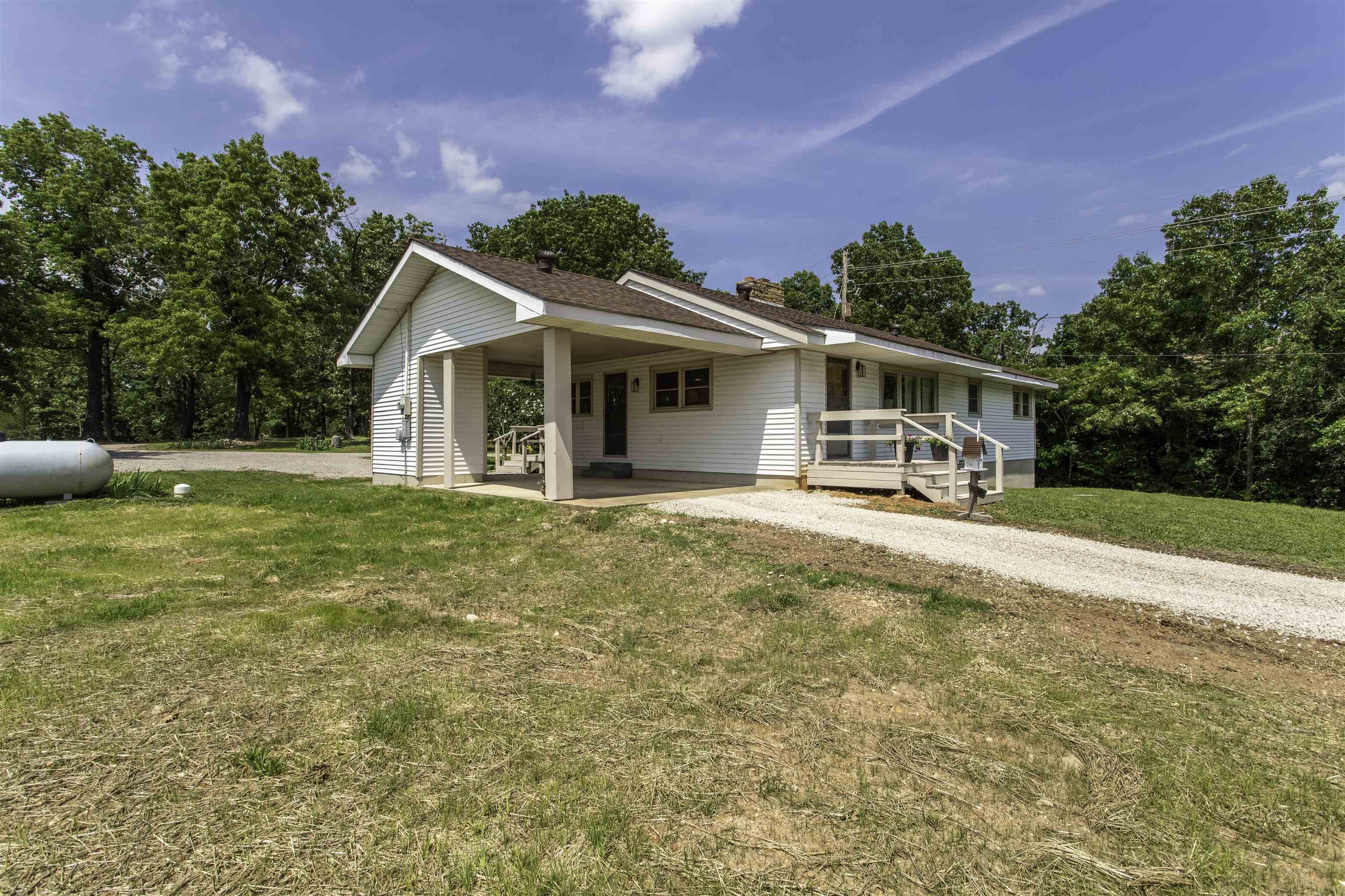 Charming Country Home in Hardy, Arkansas – Foothills of the Ozarks Perched on a gentle hilltop in the scenic foothills of the Ozarks, this inviting country home offers peaceful living with modern conveniences and stunning views. Set on approximately 2 ac with no restrictions beyond city ordinances, the property is zoned commercial/residential and sits right off the 4-lane hwy providing unique potential for home-based businesses or future development. city water and your own private well. The home features 3/2 w/1,344 sf main level, central air, gas heat, and a cozy wood-burning fireplace. A full poured-concrete basement (1,064 sf) unfinished heated and cooled with pull in garage, with a carport on main level and additional covered storage space. The circle drive offers ample parking and easy access. Step outside to find newly planted grass, mature shade trees in both front and back yards, three apple trees, a small garden, and a bounty of perennial flowers. Relax or entertain on the spacious deck just off the dining room. An 8x16 storage building is also included. This is a rare opportunity to own a versatile property in a beautiful, accessible location. Call for showing.