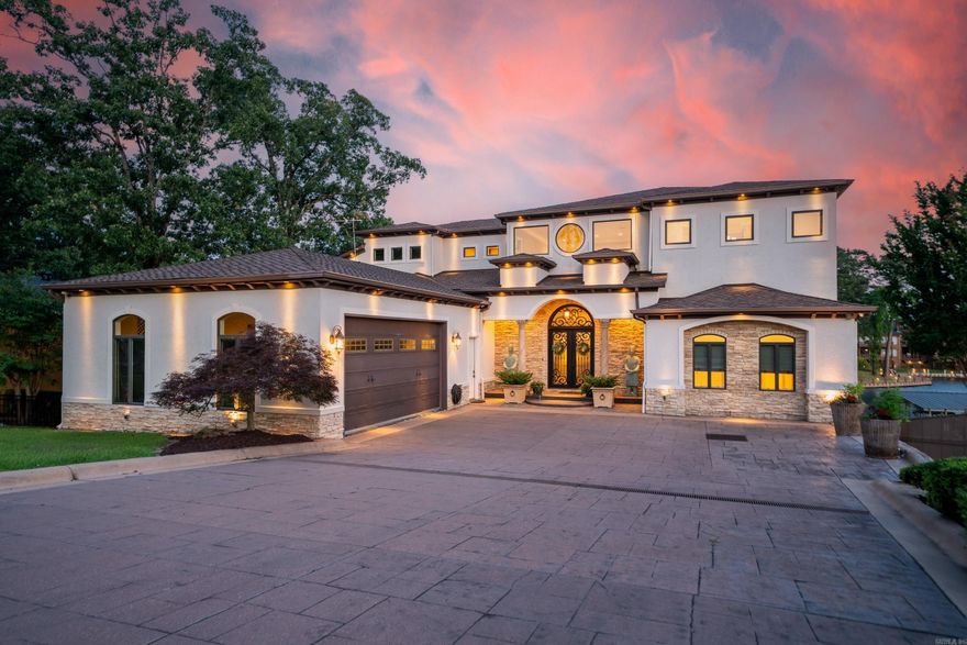 Exquisite Lakefront Estate – Luxury Living with Breathtaking Views  Welcome to an unparalleled luxury retreat, where sophisticated design meets lakefront serenity. This stunning custom-built home boasts 5 spacious bedrooms, each with private en-suite bathrooms, plus a full guest bath—ideal for entertaining in style and comfort.  Step through the arched foyer into a masterpiece of architectural detail, featuring massive ceilings, ornate woodwork, curated art niches, and expansive living and entertaining areas designed with elegance in mind. The gourmet kitchen is a chef’s dream, equipped with top-tier appliances, upscale finishes, and seamless flow into a grand dining area that opens to a covered patio with panoramic lake views.  Enjoy a variety of leisure spaces including multiple living rooms, a large home office overlooking the water, and a walk-out basement complete with full kitchen, laundry, bathroom, and a dramatic glass overhead door leading to a flagstone patio, built-in hot tub, and private boardwalk.  The primary suite is a true sanctuary featuring a sitting area, direct access to a private covered patio, spa-inspired bathroom, and tranquil lake vistas. A temperature-cont
