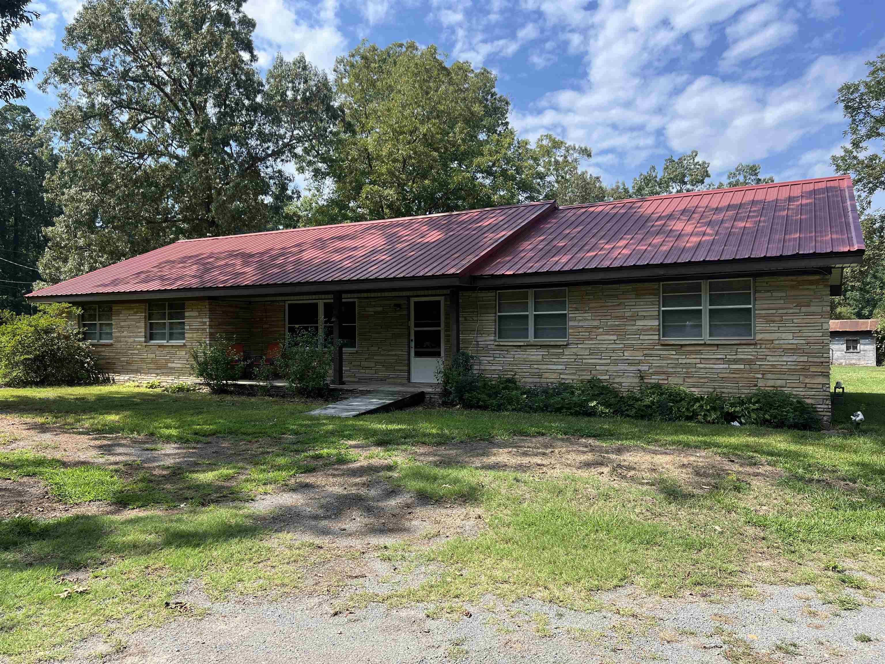 Discover this well-maintained brick home sitting on 6.49 acres of beautiful countryside. The property features open pasture, a charming older barn, and a serene pond surrounded by mature oak treesāperfect for enjoying the outdoors. Inside, youāll find three spacious bedrooms with large closets, built-in shelving, and hardwood floors that bring warmth and character throughout. The home offers a handicapped-accessible bathtub, stand-up shower, and a large utility room that was formerly a garage, providing versatile space for hobbies or storage. The kitchen includes abundant cabinets for easy organization, while a designated dining area makes gathering with family and friends a joy. Additional storage sheds add to the propertyās functionality, making this a great opportunity for those seeking comfort and country living with plenty of space to grow. The front pasture has its own septic and utilities where at one time there was a mobile home. New field lines have been ran at the home and it has a newer metal roof.