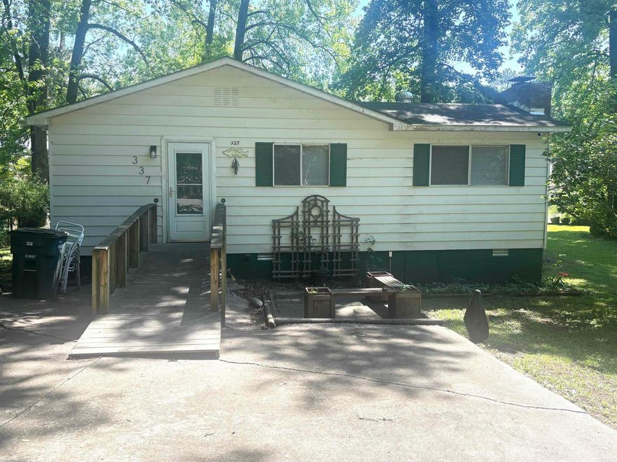 Welcome to this beautiful double lakefront property offering the perfect retreat for life on the water.  Inside, you'll find 2 comfortable bedrooms and 1 full bath, along with convenient stackable washer/dryer.  One of the bedrooms features its own sunporch- an ideal spot for morning coffee or relaxing with a view.  Step outside and enjoy everything Lake Hamilton as to offer, including a private dock, swim platform with a ladder, making it easy to spend your days swimming, boating or simply soaking up the sun.  There is also a covered area that could accommodate an RV or trailer, providing additional flexibility for guests or storage.  Recent updates include LVT flooring and roof was replace in 2012.  If you're looking for a place to unwind and truly enjoy lake living, this lake house is a must-see.  Come experience all it has to offer and make the most of your time on the water.   SOLD AS IS CONDITION.  AGENTS see remarks.