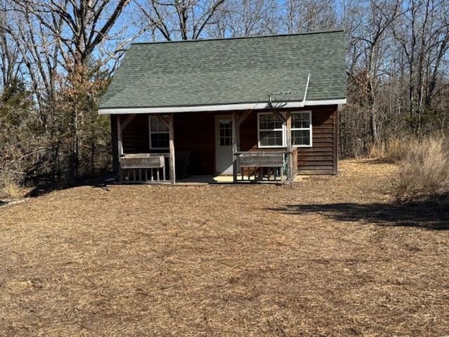 Escape to your private Ozark sanctuary with this charming 1-bedroom, 1-bath country cabin tucked away on 10 serene, wooded acres. This 520 sq. ft. retreat maximizes every inch with warm wood accents, laminate flooring, & a unique loft featuring Diamond Willow railing—perfect for extra guests. The home is move-in ready & equipped with electric baseboard heat, window AC, & essential appliances. Outside, you can unwind on the expansive covered front porch or head over to the 24x30 insulated shop. Outfitted with concrete floors, electricity, & water, the shop is a dream setup for hobbyists, craftsmen, or extra storage. The land is a nature lover’s paradise, boasting a blend of hardwoods, pines, a small pond, & a seasonal stream. With a private well & septic system already installed, the property is perfectly suited for a sustainable homestead or a premier hunting camp. Convenience meets seclusion here, as you are located just 10 minutes from Mammoth Spring State Park, world-class trout fishing, & local amenities. Whether you are looking for a turnkey Airbnb investment or a quiet weekend escape, this property offers endless potential in a sought-after natural setting.