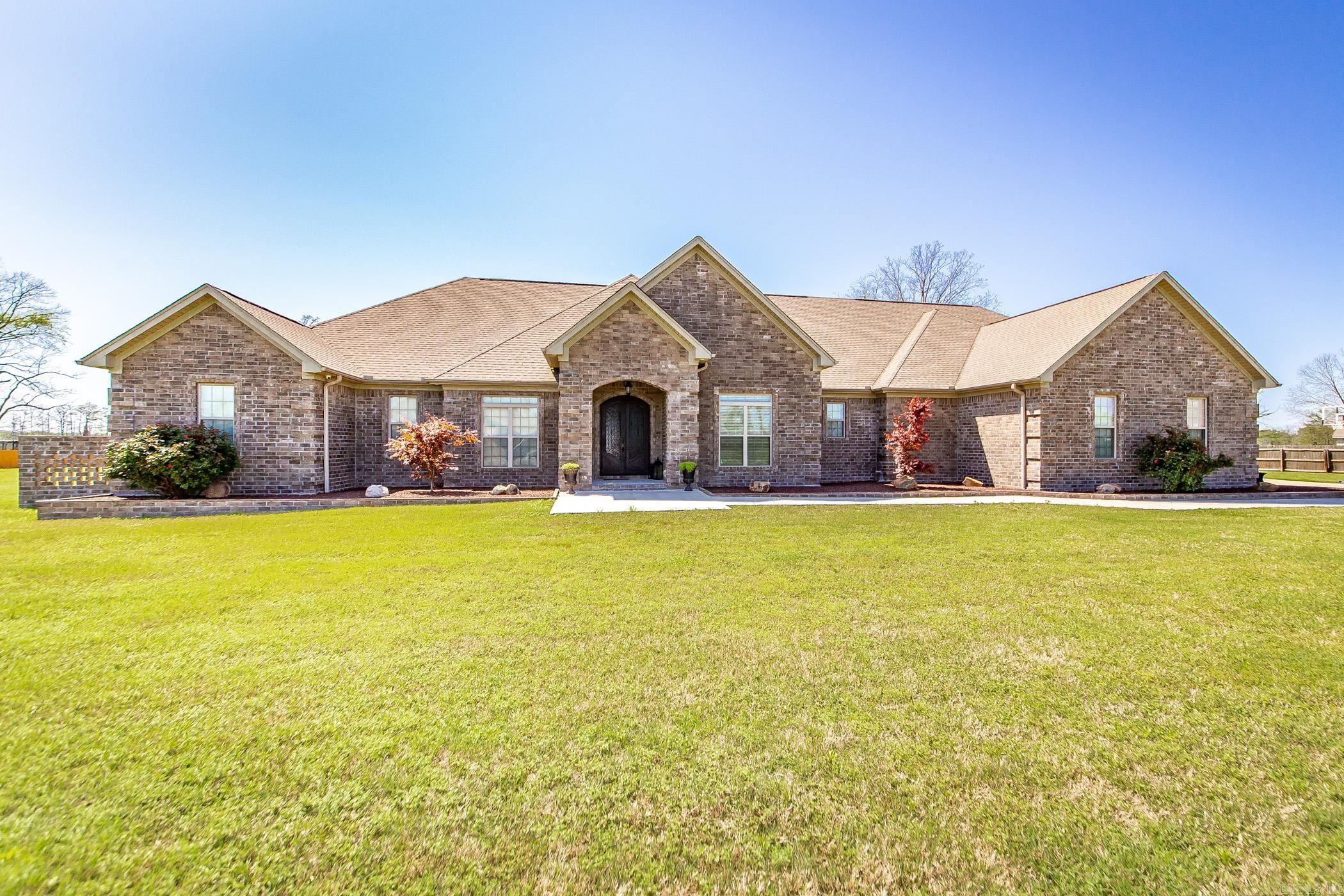 This beautiful lake property is an absolute must-see! Perfectly situated on 2.11 spacious acres, this custom-built home is thoughtfully designed for both luxury living & entertaining. Be amazed by the open layout, high-end finishes, & breathtaking views. The gourmet kitchen is a dream with double islands, slab countertops, double ovens, pot filler, & large pantry. Entertain guests in style in the sunroom, game room, or outdoor hot tub under a beautiful tongue & groove wood ceiling. Enjoy endless storage w/ an oversized laundry room, built-ins throughout, safe room, valuables room, & even a beauty salon. The home also includes 2 offices-perfect for working from home—or convert one into a 5th bedroom. The primary suite features a large sitting area & an attached fitness room. Additional highlights include: Surround sound throughout the home & shop, w/ individual room controls. Security system w/outdoor cameras, command room, & monitors. Detached shop w/half bath. 4-car garage w/epoxy flooring. Generac whole-home generator. Gazebo and covered outdoor seating areas for year-round enjoyment. Only 15 minutes to LRAFB or downtown. This home has it all including morning coffee with a view!