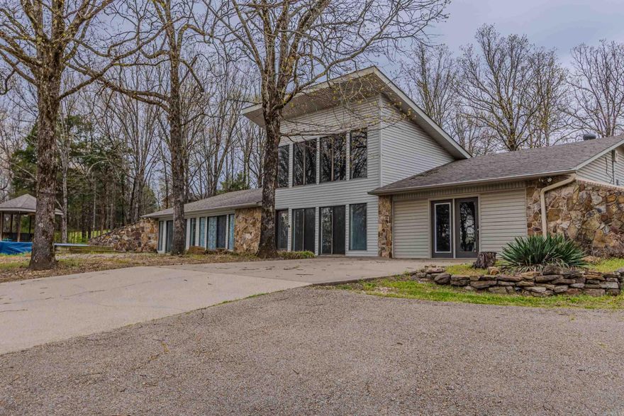 Experience the best of comfort and style with this contemporary 4-bedroom, 2-bath home featuring an open floor plan and incredible privacy with stunning views. Enjoy a beautiful living room with a gas fireplace and decorative ceiling, a den or formal living room, and a versatile office/storm shelter off the custom kitchen complete with pantry and granite countertops. The home includes a large laundry room, detached 2-car garage with shop, and sits on a wooded 4-acre corner lot inside city limits. Relax or entertain by the in-ground pool with a custom deck and gazebo—your private retreat awaits!