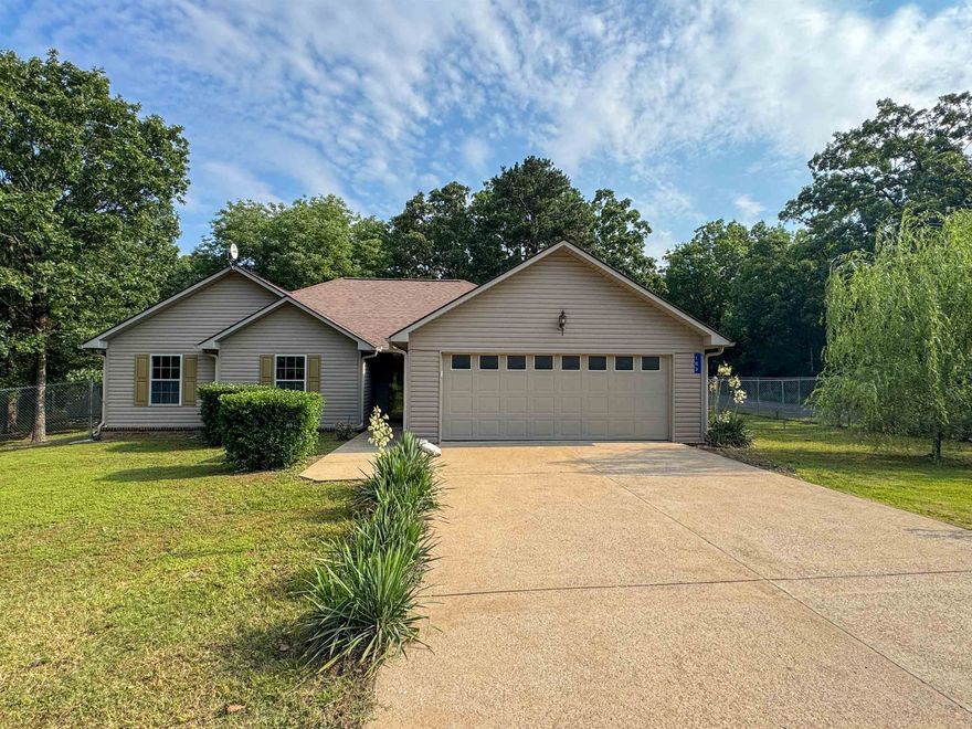 Enjoy space, privacy, and convenience with this beautifully updated 3 bed, 2 bath home on 1.8 acres—just 1 mile from Cave City Elementary. Thoughtfully landscaped and surrounded by mature trees, this property offers a peaceful setting just minutes from town. Inside, you'll find 1,595 sqft of freshly painted living space with brand-new carpet and an inviting layout. The living room features a tiled fireplace with electric insert, and the dining area includes a bay window overlooking the fenced backyard. The kitchen comes equipped with stainless steel appliances—washer, dryer, and fridge all convey. The spacious primary suite includes his and hers walk-in closets, dual vanities, a jetted tub, and a separate shower. Guest bedrooms also offer walk-in closets. Outside, enjoy a covered patio, freshly painted deck, 6’ chain-link fence, and a detached shed with electricity, a garage door, and workbench. The attached, true 2-car garage includes two storage closets. Families will appreciate the highly rated Cave City School District, known for small class sizes, award-winning campuses, a 95% graduation rate, and strong college and career prep with AP and gifted programs.