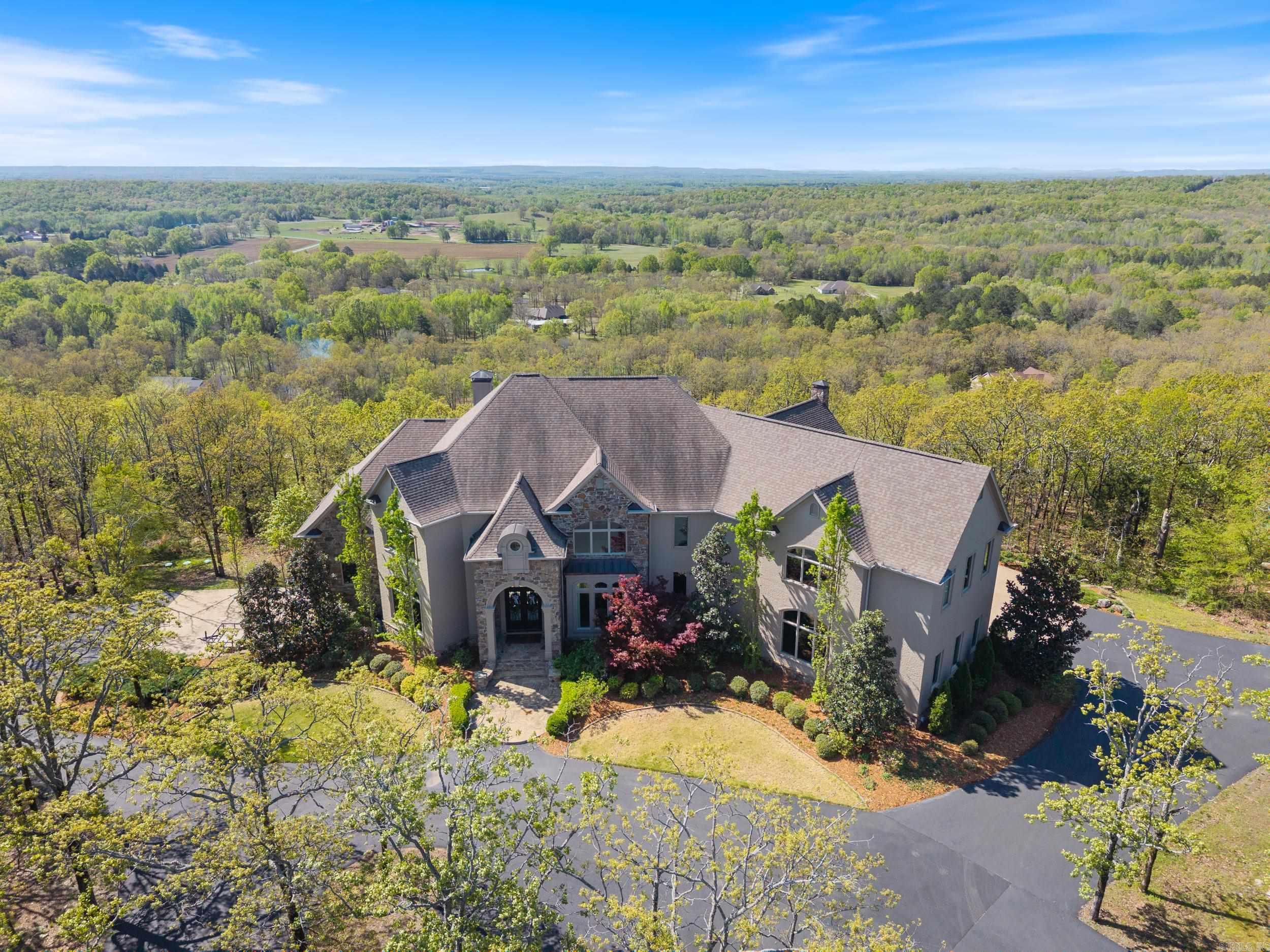 This exquisite home with expansive vista views is unparalleled in both elegance and privacy. Step into the foyer through the custom iron door and behold the floating staircase with custom iron railings and gorgeous walnut floors which continue through the main and upper levels. The kitchen is beautifully designed with Schonbek chandeliers, quartzite counters, marble backsplashes, and reclaimed wood beams. The kitchen also includes a Thermador double fridge & freezer, 60" range with double oven, and so much more. Entertaining is a breeze with a butler's pantry, working pantry, and three dining areas each with their own thoughtful details. The primary suite is a masterpiece in design featuring a custom ArcusStone ceiling modeled after St. Mark’s Square in Venice which is echoed in elements throughout the suite. The heated marble bathroom floors, steam/jet shower, closet island, and specialty lighting are just a few of the special touches. Other highlights of the home include fun surprises such as secret rooms and tunnel slides, a second kitchen and laundry room, two 3-car garages, & exceptional structural components. Please reach out for additional photos and a full list of features.