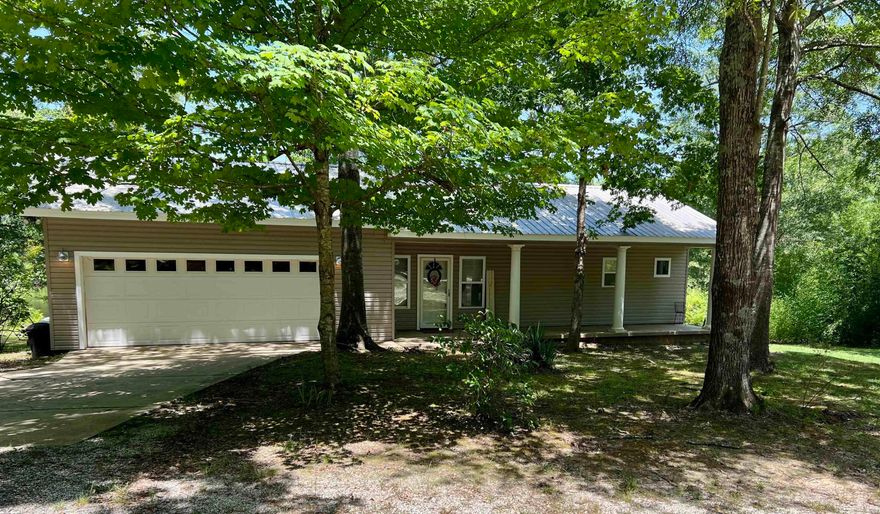 Nestled just minutes from both Henderson State University and Ouachita Baptist University, this 10-acre property offers a perfect blend of convenience and natural serenity. The well-kept 1-bedroom, 1-bathroom home sits on a gentle rise overlooking a beautiful 3-acre stocked pond—ideal for peaceful mornings or relaxing evenings on the back deck.  Designed with an open floor plan, the home feels spacious and inviting, with scenic views that bring the outdoors in. A portion of the garage has been thoughtfully converted into a large storage room, providing extra functionality without sacrificing space.