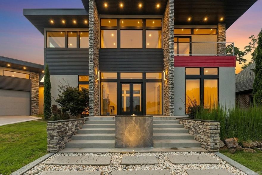 31 La Scala Court is a modern masterpiece where stone, metal, and glass converge in flawless harmony. A striking fountain sets the stage for the double-door entry, opening to soaring ceilings and walls of glass. At the heart of the home, a chef’s kitchen showcases a 17-foot waterfall island, sleek custom cabinetry, and integrated appliances. A stunning custom staircase rises to a versatile bonus room and two guest suites connected by a unique shared suite bath with private vanities and toilets. The owner’s suite is a retreat unto itself with a cozy sitting area, office nook, and a spa-worthy bath overlooking the serene backyard water feature. The boutique-style custom closet connects seamlessly to the laundry room for convenience and ease. Every inch reflects exquisite attention to detail, from dramatic architectural elements to thoughtful design choices. Set on a premier lot in a gated cul-de-sac, this residence is offered for the first time ever. This is an unparalleled opportunity to own a work of art that embodies modern luxury and timeless design. For those who demand the extraordinary, this is the home that defines it. Yearly dues cover lawn care.