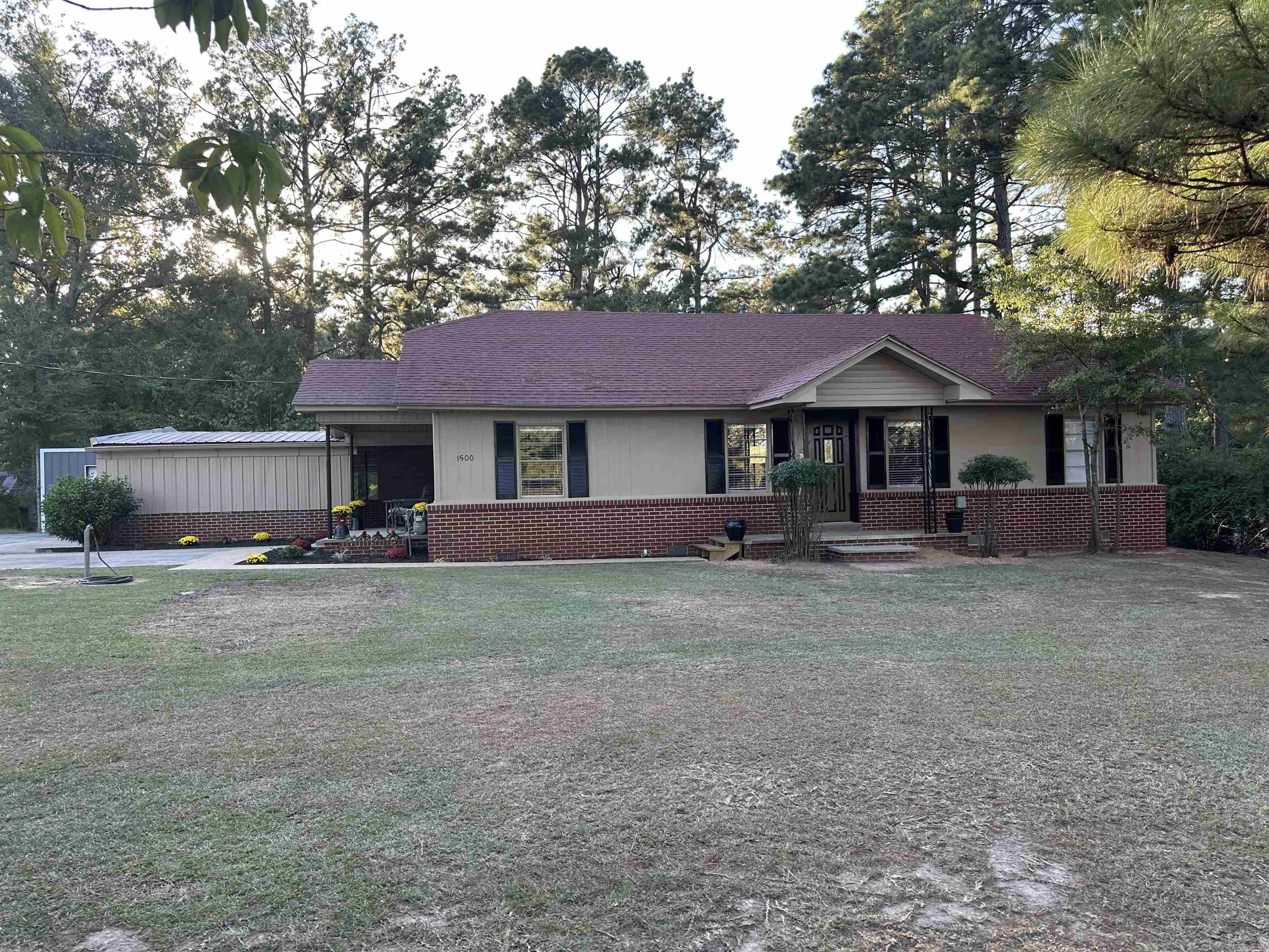 The three-bedroom, three-bath home sits on a larger lot and features a three-car carport, a new fire pit area, and a metal shop with a large overhead door. The home has undergone extensive renovations, including new paint, replaced boards, new flooring, new bathrooms, updated electrical, plumbing and yard work. It offers multiple living spaces, including a living room, den, and dining room.