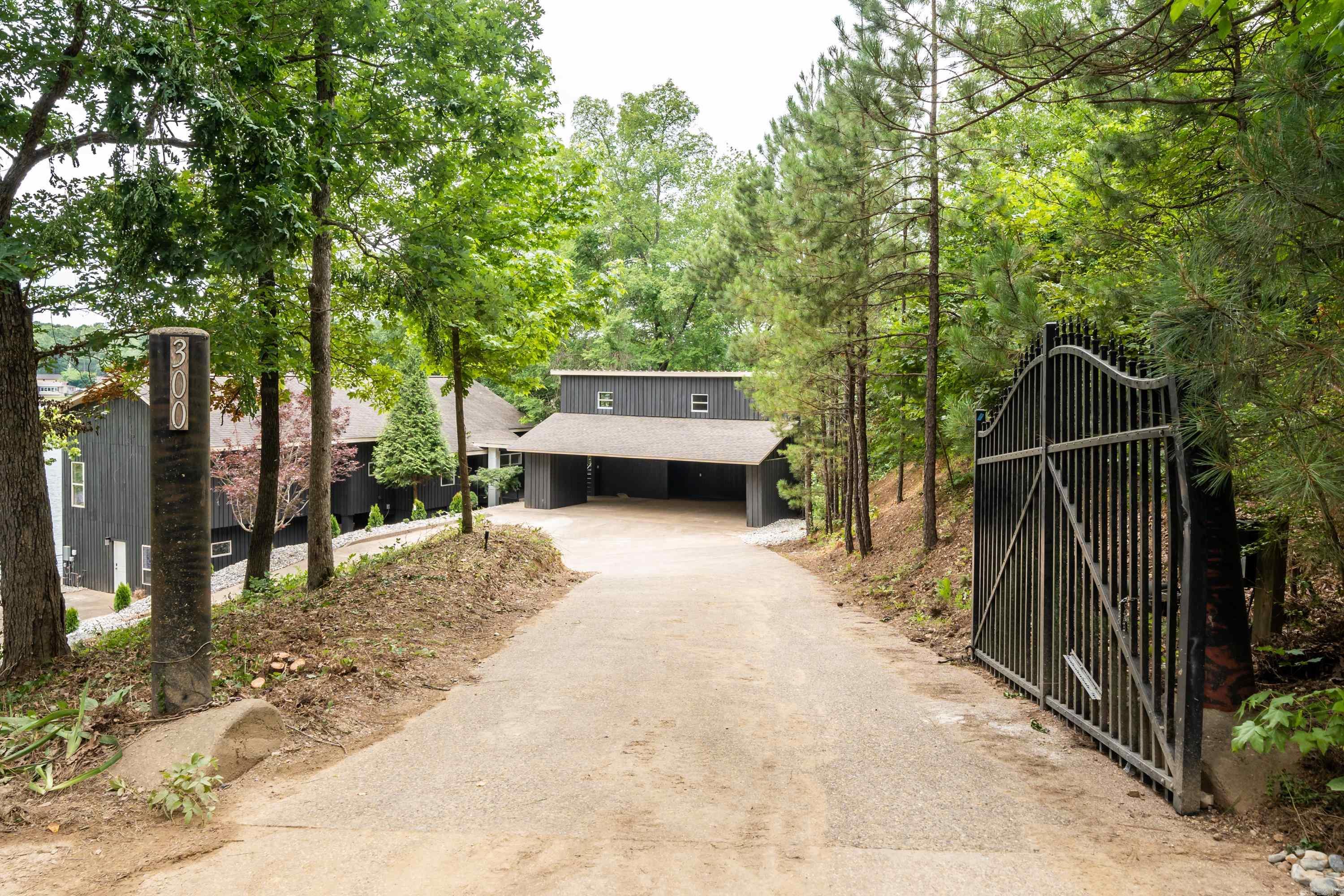 Welcome to this magnificent lakefront oasis on prestigious Lake Hamilton, where luxury and functionality harmoniously merge! This exquisite home boasts a contemporary open concept design, allowing seamless transitions between living spaces while offering breathtaking panoramic views of the sparkling lake from every corner. As you step inside, you are greeted by a grand foyer featuring soaring ceilings, an abundance of natural light, creating an inviting atmosphere. The main living area, adorned with elegant flooring and floor-to-ceiling windows, serves as the heart of the home.  Adjacent to the main living area, you'll find a luxurious primary suite, offering a sanctuary overlooking the tranquil waters. The primary bedroom features a cozy sitting area, a walk-in closet, and a lavish ensuite bathroom complete with a soaking tub, a glass-enclosed shower, and dual vanities. Moving downstairs you'll find a massive amount of open concept space incorporating lake living at its finest. An oversized deck spans the back of the home, offering a magnificent space for entertaining! Outside city limits, investors take notice, great VRBO potential!