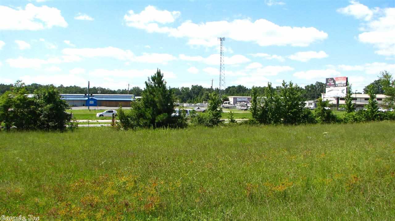Great visibility from 67/167. 180' of frontage, level and mostly cleared. Partially fenced with 6' chain-link. 12'x32' building currently used as car sales office. In addition to this lot there are 7 more lots to choose from ranging from 3.8 - 6.5 acres. Parcels begin on southern boundary of Wild Hog Liquor Store and continue to northern boundary of former Busy Bee location. City water, commercial zoning in place. Some lots include metal buildings pictured. Call office for more details.