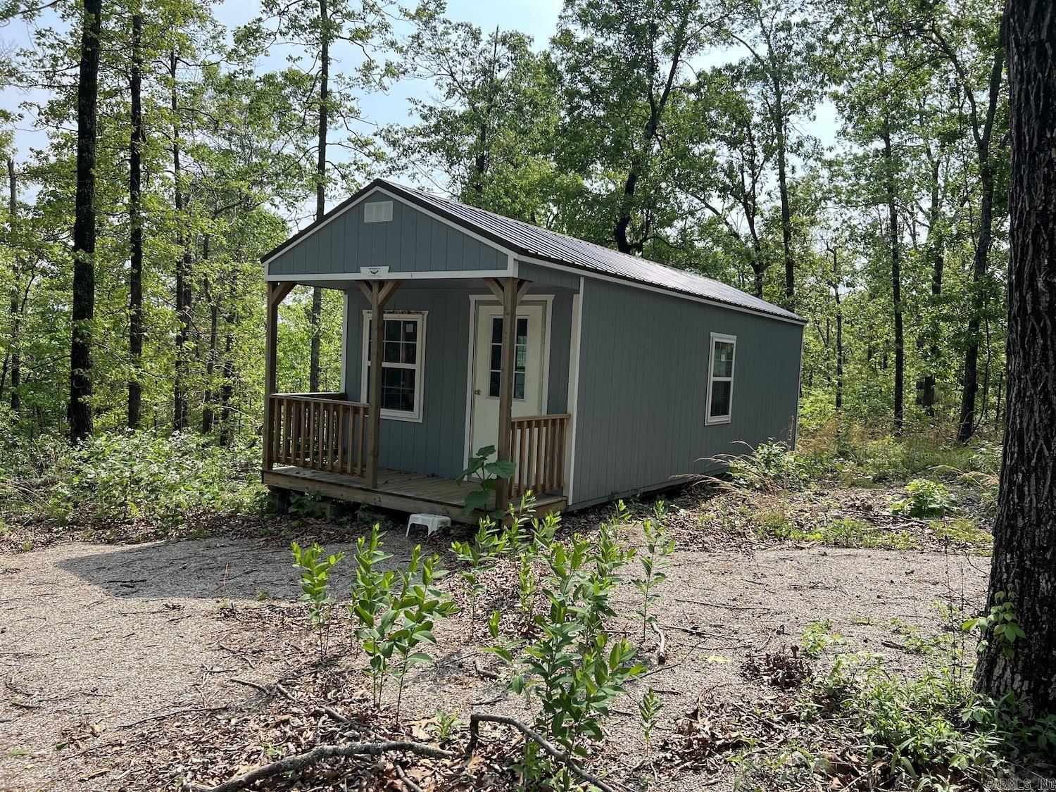 5 acres all in woods ATV trails, appears to be in a good hunting area. Has a 16x32 new cabin unfinished inside and a 10x16 storage building. All set up to move in for camping and roughing it in the wilds. You can drive to the property, but part of the road is unimproved for 600 feet or so, but is a platted road. Electric is about 1000 feet from property might be accessible, but currently being operated as an off Grid property. Pretty mostly wooded acreage a good get away. Spring River not far.