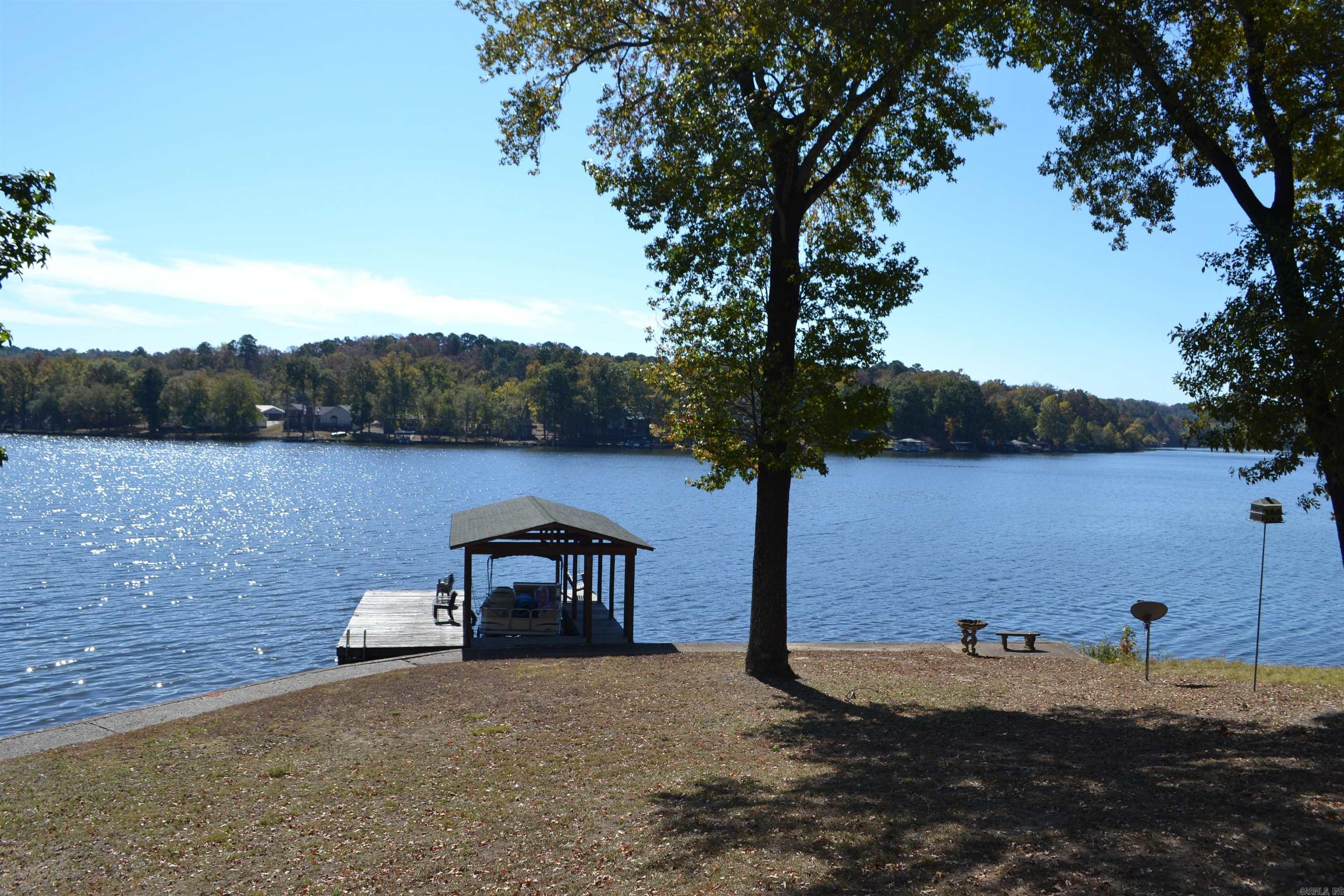 This one of a kind property on Lake Catherine has a main house (2550 sf) w/ 3 BR & 2 1/2 baths w/ a large living room on both levels and a separate guest house (1120 sf) w/ 3 BR & 1 1/2 baths. Each home has its own electrical supply creating 2 separate addresses but sit on one 2 acre parcel (MOL) of land. Both houses have a total combined living area of approx. 3670 sf. (see agent remarks regarding sf). Both houses have full kitchens and washer/dryers. Property is located in the county and does not require city business permitting to operate a nightly rental offering an unlimited business opportunity. Property offers over 250' of shoreline with a rock seawall, a 2 stall covered boat house with overhead garage doors, a 1 stall covered boat slip with swim platform, a 20' x 20' covered cooking/party shack and over 1500' of outdoor decks. You must experience all this property has to offer to truly appreciate it. Located off of the Malvern Hwy and in the Lakeside School District it is just minutes from the bypass.