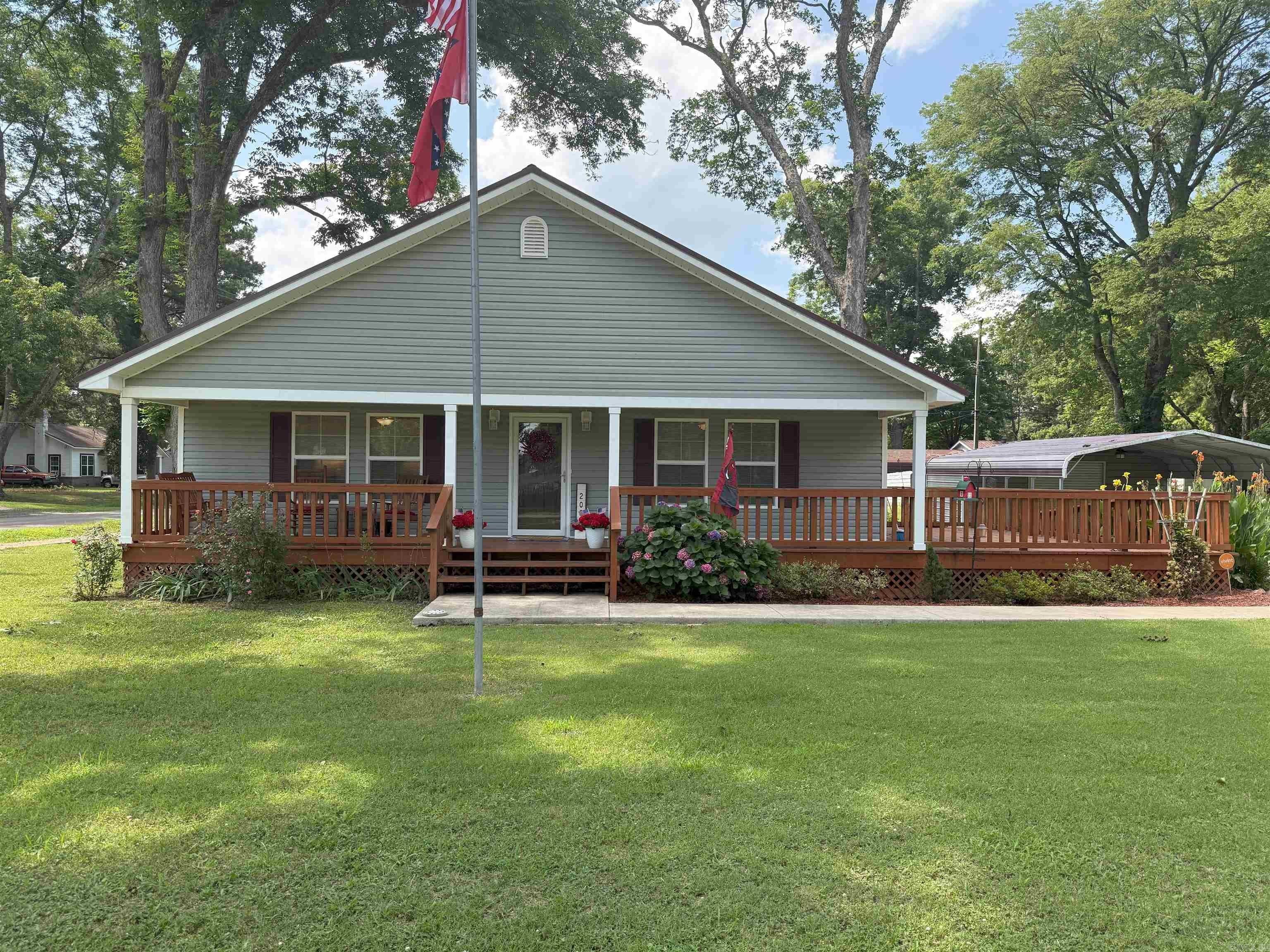 This meticulously maintained 2 bed, 2 bath home, built in 2018, sits on three spacious city lots and offers comfort, convenience, and quality throughout. Features include luxury vinyl plank flooring in main living areas, carpeted bedrooms, and tiled bathrooms. The open-concept layout flows to an oversized deck—ideal for entertaining—alongside a 20x30 carport for ample covered parking. Designed with accessibility in mind, the home includes wide doorways, an entry ramp, and a roll-in shower in the primary suite. Bonus features include an 18x14 storage building, additional outdoor storage, and a whole-house generator for added peace of mind. A rare find with space inside and out—ready for its next owner!
