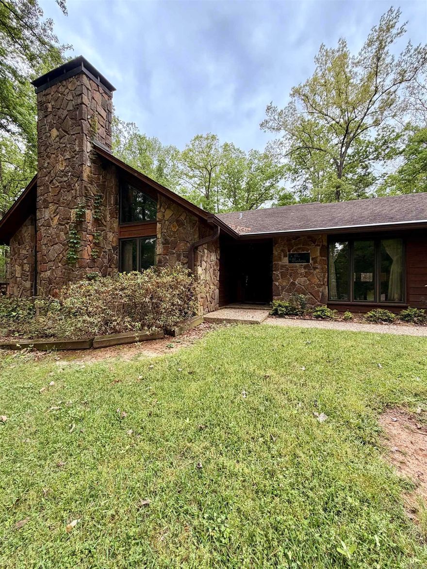 Perched on 2.62 acres in a beautiful hilltop setting, this stunning 4BR/2.5BA stone and cedar home offers space, character, and exceptional features throughout. The living room showcases a dramatic stone fireplace, vaulted wood ceilings, wet bar, and built-in entertainment center, along with Pella windows featuring built-in blinds. The adjoining kitchen and dining area boast rich Wood-Mode cabinetry, center island with Jenn-Air cooktop, appliance garage, trash compactor, pantry, double ovens, and a skylight you can open or close as desired. A spacious sewing room—complete with sink and built-in desk—would make a perfect craft, hobby, or exercise room. Just off the kitchen, the cozy family room features tongue-and-groove wood walls and opens to a large patio ideal for entertaining. The primary suite offers double sinks and a steam shower with timer. Three additional bedrooms are freshly painted with generous closets. Oversized garage, circular drive, whole-house generator, attic fan, and more.