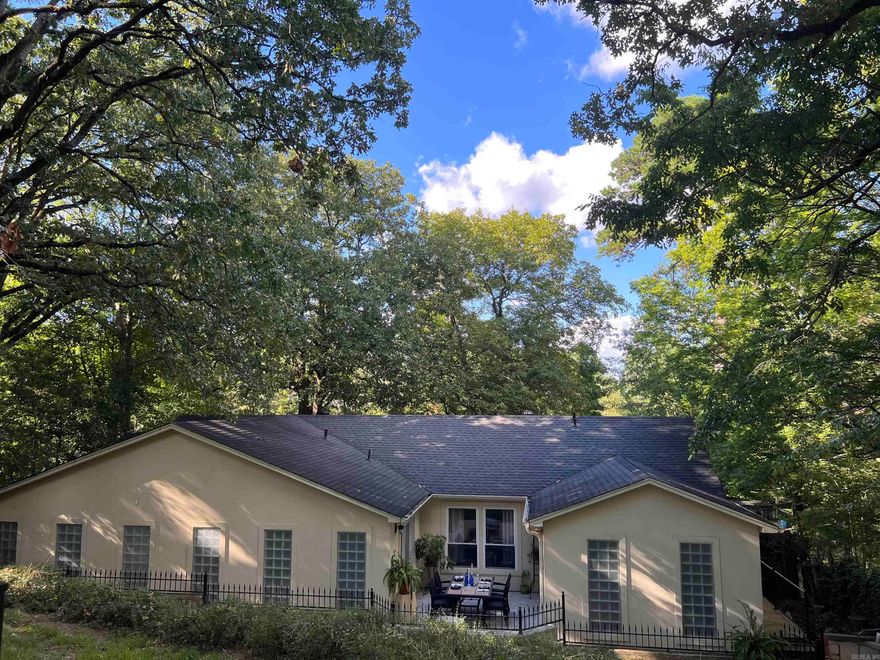 Nestled in the serenity of a wooded retreat, this charming one-level  offers a perfect blend of tranquility and convenience. Boasting 4 bedrooms and 3 baths, the residence provides ample space for comfortable living. The formal living room and dining combo create an inviting atmosphere for gatherings, while the updated kitchen features stainless appliances and elegant travertine floors. With a strategic location off the beaten path, the property offers a peaceful escape, yet remains in close proximity to a variety of amenities. Shopping, dining, and area hospitals are just a stone's throw away, ensuring you have everything you need within reach. The outdoor space is a true highlight, featuring a 2-car carport for convenience and two decks that enhance the overall living experience.  One deck is perfect for al fresco dining, providing a scenic backdrop of nature, while the second deck is ideal for lounging and soaking in the picturesque wooded views. Embrace the perfect balance of nature and modern living in this delightful residence.