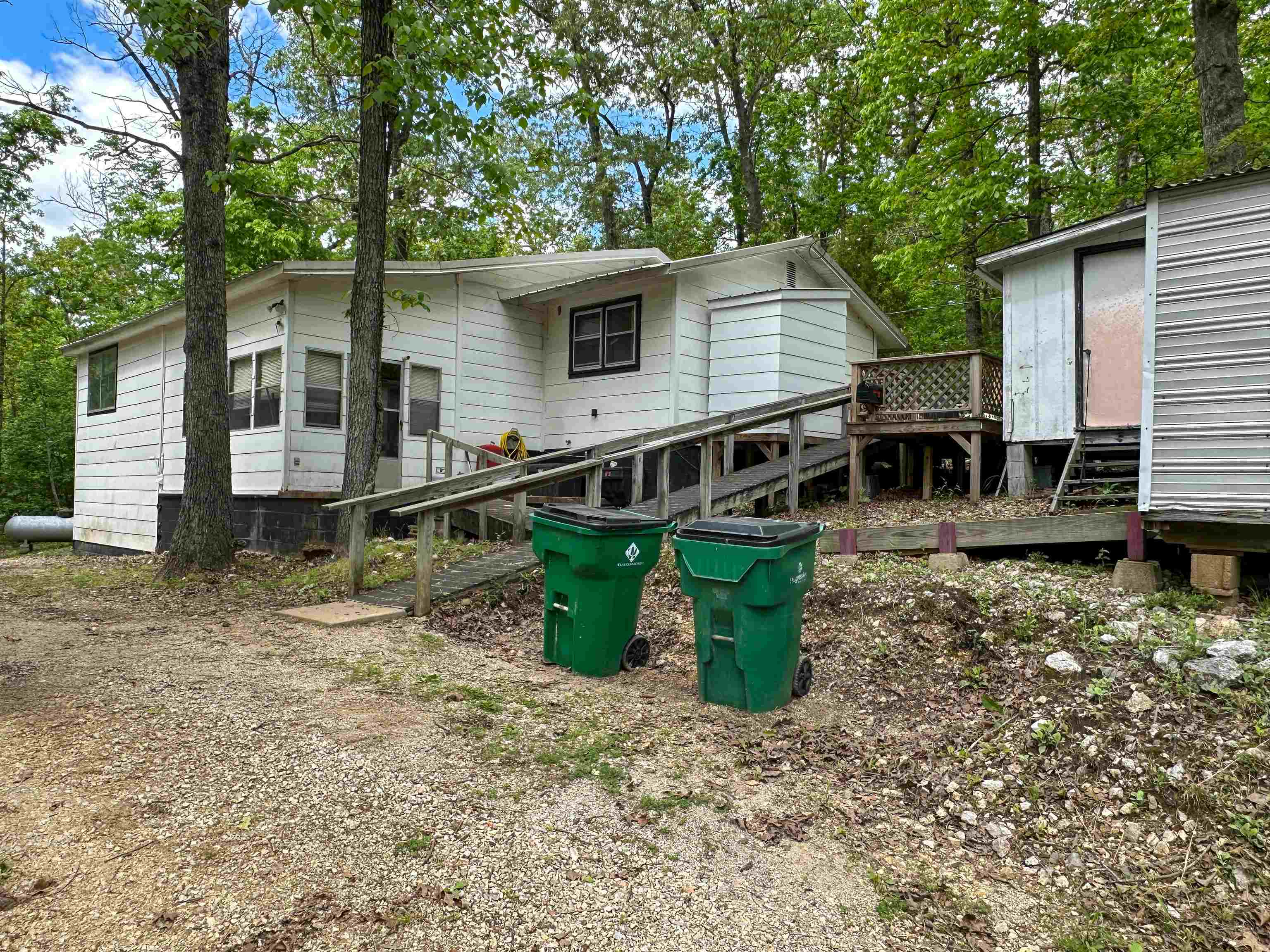 Located on an approx. ½ acre wooded corner lot, this private home features a versatile floor plan with 2-3 bedrooms and 2 ½ bathrooms, handicap accessible and ample living space. Enjoy cozy evenings by the fireplace, the private deck and the peace of mind that comes with a whole house generator. Multiple outbuildings are perfect for storage or hobbies, and a storm shelter for added security. Embrace the tranquility and privacy this property affords.