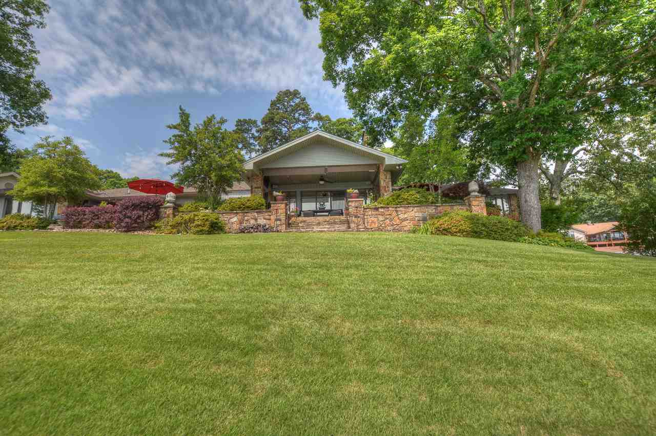 Take in Sweeping Views from Every Angle of this Sprawling One-Story Estate on Lake Hamilton. Sunlight bounces off the gorgeous polished wood vaulted ceilings in the main living spaces. A large family room spills out to fantastic entertaining spaces, surrounded by gorgeous landscaping. The quality of the superior custom crafted interiors is exquisite. A tranquil master suite offers a personal retreat with fireplace, sunken jetted tub and walls of glass that opens up to the serene outdoor space.