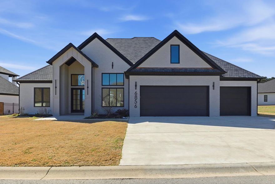 Located within a gated subdivision featuring a neighborhood pond, this home offers modern design with refined finishes throughout. The entry opens to 15-foot ceilings, with 12-foot ceilings continuing across the main level, creating a bright, open atmosphere filled with natural light. Just off the main living areas, a dedicated office provides a quiet, flexible space for work, study, or creative use. Hardwood flooring runs throughout the main level, anchored by an open-concept great room with an LED electric fireplace. The kitchen features a waterfall island, a six-burner gas range, oversized refrigerator, walk-in pantry, and custom cabinetry, with the adjacent dining area accented by a tray ceiling and dimmable lighting. The main-level primary suite includes separate floating vanities, a soaking tub, an expansive walk-in shower, and generous closet space with direct access to the laundry room. Two additional bedrooms, a full bath, and a half bath complete the main level. Upstairs offers a private bedroom with a full bath. Outdoor highlights include a covered patio with electrical outlets, a spacious flat backyard, an irrigation system, and a three-car garage.