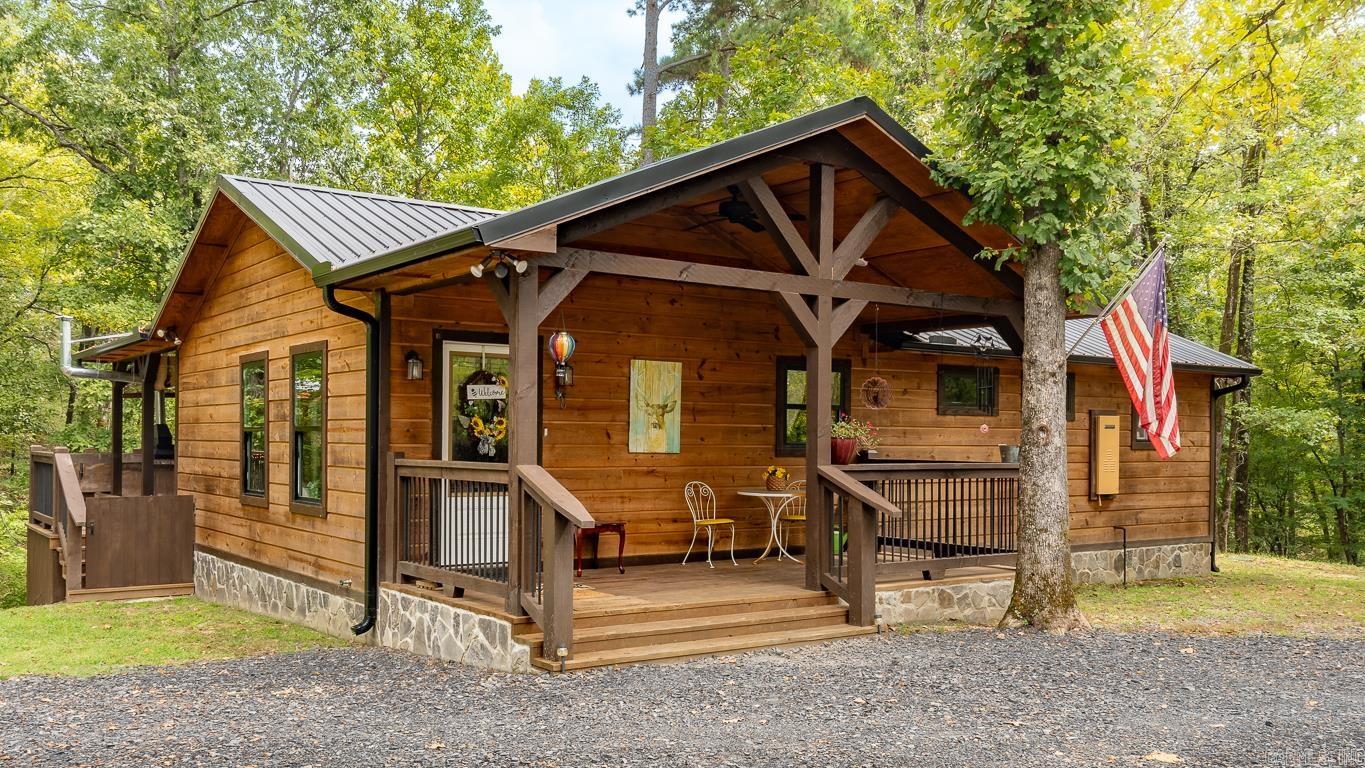 Escape to your private oasis! Nestled on 3.46 serene acres just beyond Woodland Hills subdivision, this stunning cabin offers the perfect blend of comfort and nature. Built in 2022, this 1-bedroom, 1.5-bathroom gem features 1,008 sq. ft. of thoughtfully designed living space. Step inside to find a cozy interior with an inviting atmosphere, perfect for relaxing after a day of exploring. The indoor fireplace adds a touch of warmth, while the spacious layout makes entertaining a breeze. Outside, you'll discover a true retreat. Enjoy evenings by the outdoor fireplace, listen to the gentle sounds of the nearby stream, or unwind on the charming wood swing. The expansive property provides ample space for outdoor activities or simply soaking in the natural beauty that surrounds you. Need storage? A convenient 20x20 storage building is included, ensuring you have plenty of room for all your outdoor gear. Best of all, this cabin comes fully furnished—just bring your suitcase and start enjoying your new getaway! Don’t miss your chance to own this idyllic cabin in Hochatown, where peace and tranquility await. Schedule your showing today!