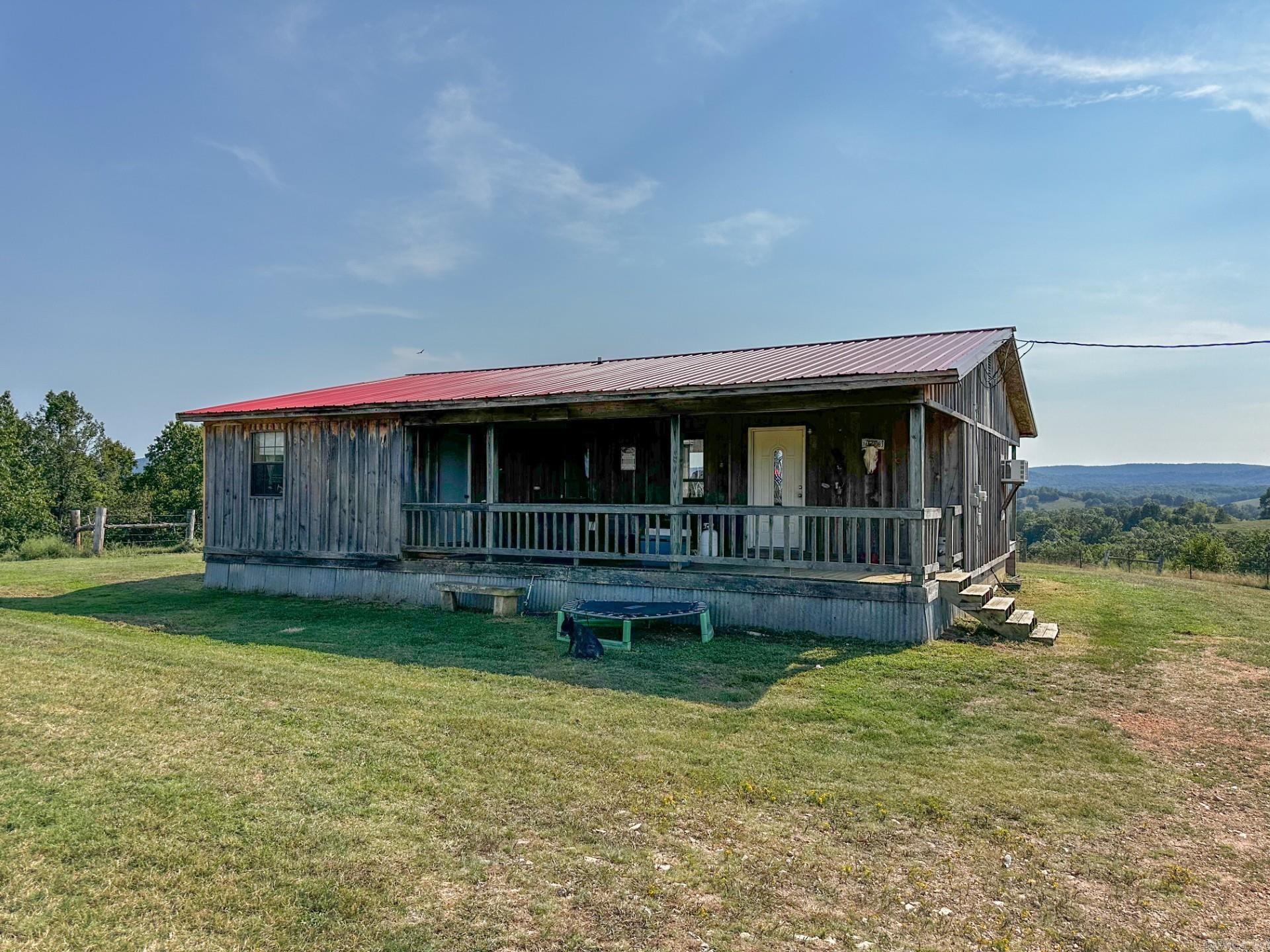 No: 25001, This 2 bedroom 1 bath home sits on 20 acres with views that stretch into the next county and beyond. The 1008 square foot house has an open floor plan with a 10x16 enclosed storage space, a bathroom with a soaking tub and stand up shower, and a gas log fireplace for cozy evenings. The home needs a little TLC but it would make a perfect guest house, nightly rental, starter home. The real gem is the chance to build your dream home on the ridge where the views are absolutely spectacular. Imagine waking up each morning to rolling hills and sunsets that seem to go on forever. The land features about 12 acres of fenced pasture along with a pond, an old barn, and a chicken coop. Wildlife is abundant and the private drive gives you true seclusion with no neighbors in sight. A new water well and a three quarter RV hookup are already in place. This property is full of opportunity whether you want a quiet getaway or a forever home in the country. Priced at $225,000.