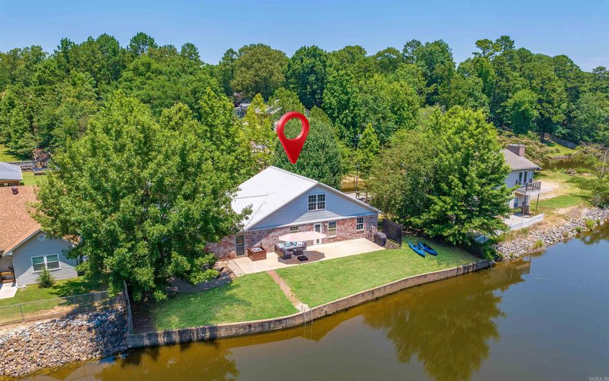 Perfect location for your full-time residence, weekender or investment property on the beautiful shores of Lake Hamilton. Currently operating as a short term rental. This property boasts a large living/dining area great for entertaining. The 3bed 2bath home with loft for extra beds is well maintained with new interior paint, lighting fixtures, cabinet pulls, landscaping and a new floating 6x28 dock. Enjoy relaxing lakeside by the stone fire pit, or take off on the water for all the boating fun on Lake Hamilton!