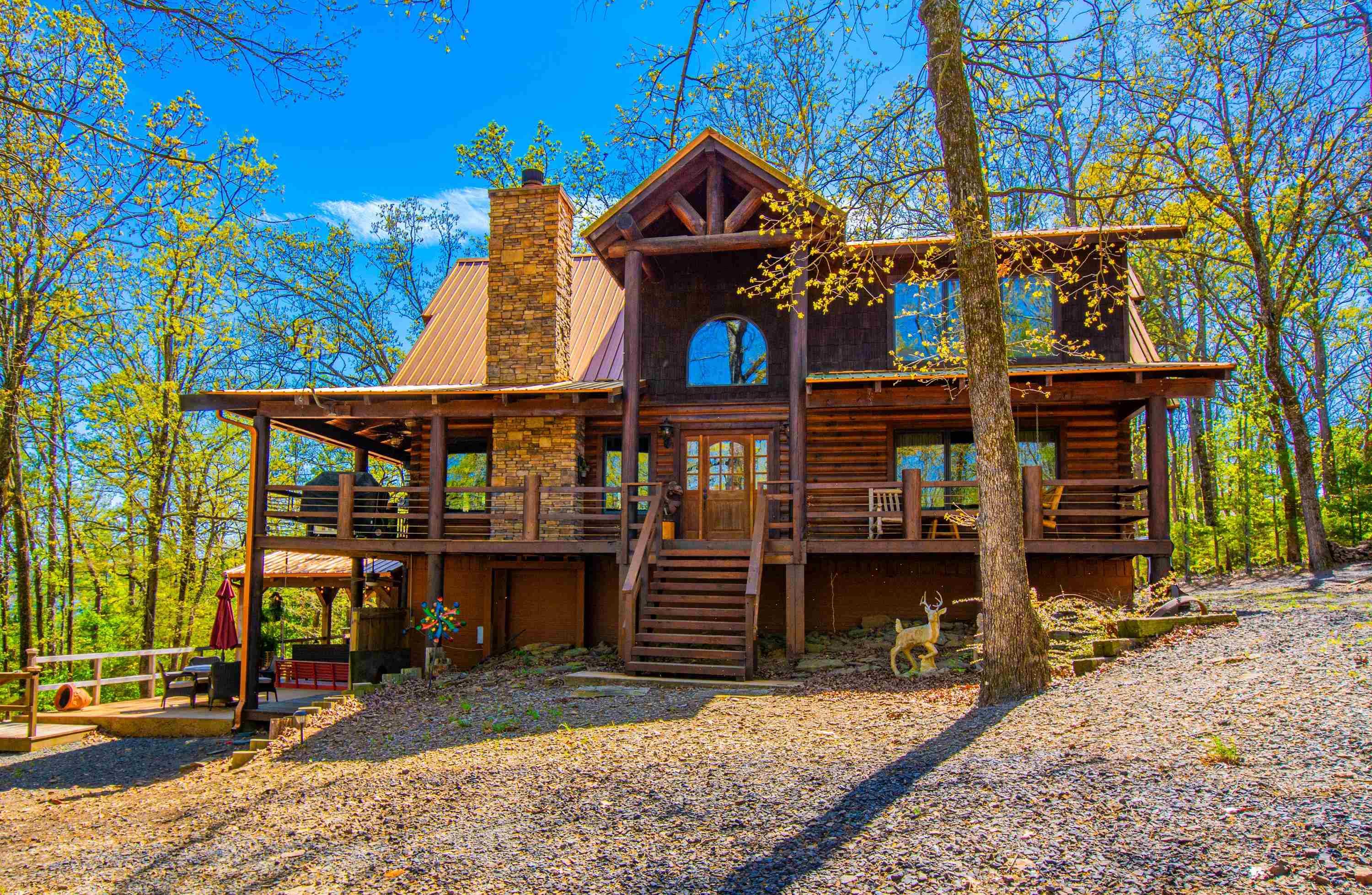 Experience the ultimate lakeside living in the stunning lodge style home, that offers perfect blend of rustic charm and modern luxury. This exceptional property features a wrap around porch that invites you to relax and enjoy the serene surrounding, while a lakefront boat slip provides easy access to water activities. Enjoy the warmth of this lodge style hybrid construction; log and conventional covered patio area with fireplace. Don't miss out on this extraordinary opportunity to own a one-of-kind home.