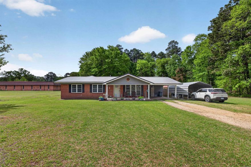 Welcome to 391 West Main Street in Sparkman, Arkansas—where comfort meets space and country charm. **Completely updated in 2020**, this home offers modern finishes while maintaining a warm, inviting feel. Situated on a beautiful piece of land, the property provides a peaceful setting with mature trees, open green space, and plenty of room to enjoy the outdoors. From the aerial view, you can truly appreciate the privacy and size of the lot, complete with a fenced backyard, storage buildings, and a cozy firepit area perfect for gatherings. Inside, the kitchen is both functional and inviting, featuring abundant cabinetry, modern appliances, and a large center island that provides extra prep space and seating—ideal for everyday living or entertaining. The primary suite is spacious and relaxing, offering plenty of room for oversized furniture along with multiple windows that bring in natural light. The en-suite bathroom showcases a beautifully tiled walk-in shower with upgraded finishes, creating a spa-like feel. Step outside to enjoy the expansive backyard, complete with a covered patio area, storage shed, and space for for play, pets, or gardening.
