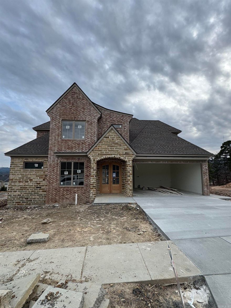 We're excited to introduce Mountain Brook, West Little Rock's newest and most desirable neighborhood. This community is conveniently located off Highway 10, just behind The Ranch and the Bank OZK campus, and only minutes away from Little Rock Christian, Joe T. Robinson, and Don Roberts Elementary.  This family-friendly home design features a grand foyer and a spacious open living area with 10-foot ceilings and 8-foot wood doors throughout. The kitchen is equipped with custom-built cabinets, an oversized pantry, and a wet bar off the living room, perfect for entertaining. Step outside to a large covered patio where you can enjoy sunset views of Chenal Mountain.  The master suite boasts a decadent design, including huge walk-in closets, a luxurious tub, and a supersized walk-in shower with two shower heads. This home also offers a private office downstairs, with three additional bedrooms, three full bathrooms, and a separate playroom upstairs.  This home is set to be complete in April 2026. We invite you to come and explore it today!
