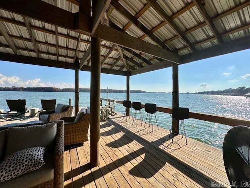 Stunning Lakefront Showplace  This amazing lake home offers expansive lake frontage and picture-perfect views from nearly every room. Designed with the charm of a Southern Living showcase, the home features two separate lakeside decks—ideal for relaxing, entertaining, and enjoying the outdoors in every season.  Inside, you’ll find a beautifully updated kitchen complete with a butcher-block island, upscale appliances, and fresh interior paint completed within the last couple of years. A stylish bar overlooks the office and the open living area, which is anchored by a cozy fireplace. All furnishings will remain with the home, with the exception of artwork and personal belongings. Every bath has been tastefully updated, adding to the home’s turnkey appeal.  Outside, the property continues to impress with a meticulously maintained lawn, a brand-new pier offering generous entertainment space for gatherings of any size, and a like-new pontoon boat plus two jet skis that will remain with the sale. The adjoining lot is also included, along with a new seawall surrounding both parcels. This rare offering truly has it all—beautifully finished interiors, exceptional outdoor living sp