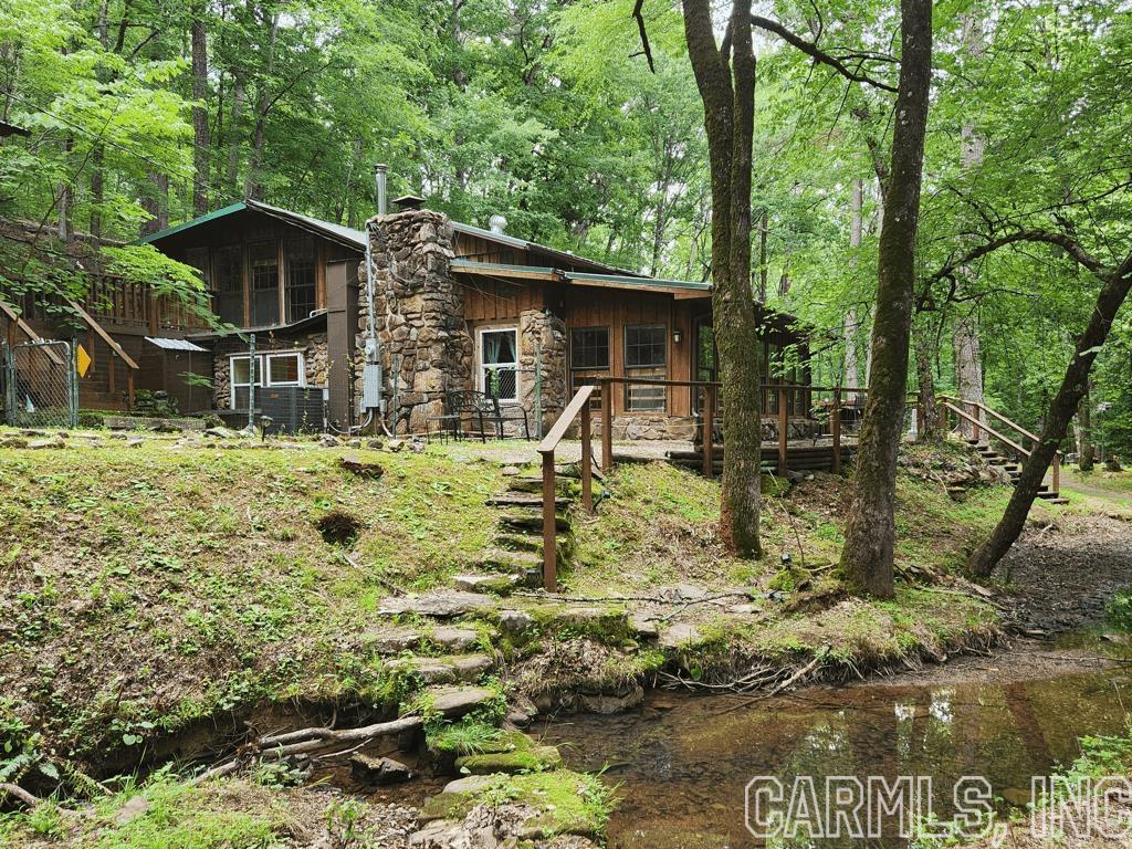 This is a rare find. 0.91-acre tract that is steps away from Lake Ouachita (you can see the water when you drive up). There is literally a walking path to the water. It is tucked away in a quiet setting with beautiful trees and a year-round creek. Currently a vacation rental with a positive cash flow, and 3+ year track record, and a 4.9-star rating. This 1745 sq ft hideaway sleeps 16 and features: 5 private bedrooms, 2 open bedrooms, 4 bathrooms, and 5 fireplaces. It comes fully furnished with extra bedding and towels, upper and lower decks, lots of natural light, a shed stocked with kayaks/paddle boards, life jackets, and other water toys. Newly updated electrical and HVAC. Spacious outdoor living areas with grill and fire pit. I can see myself getting up and paddling on the lake every morning. Quite the unique experience. Do not miss out on this one.