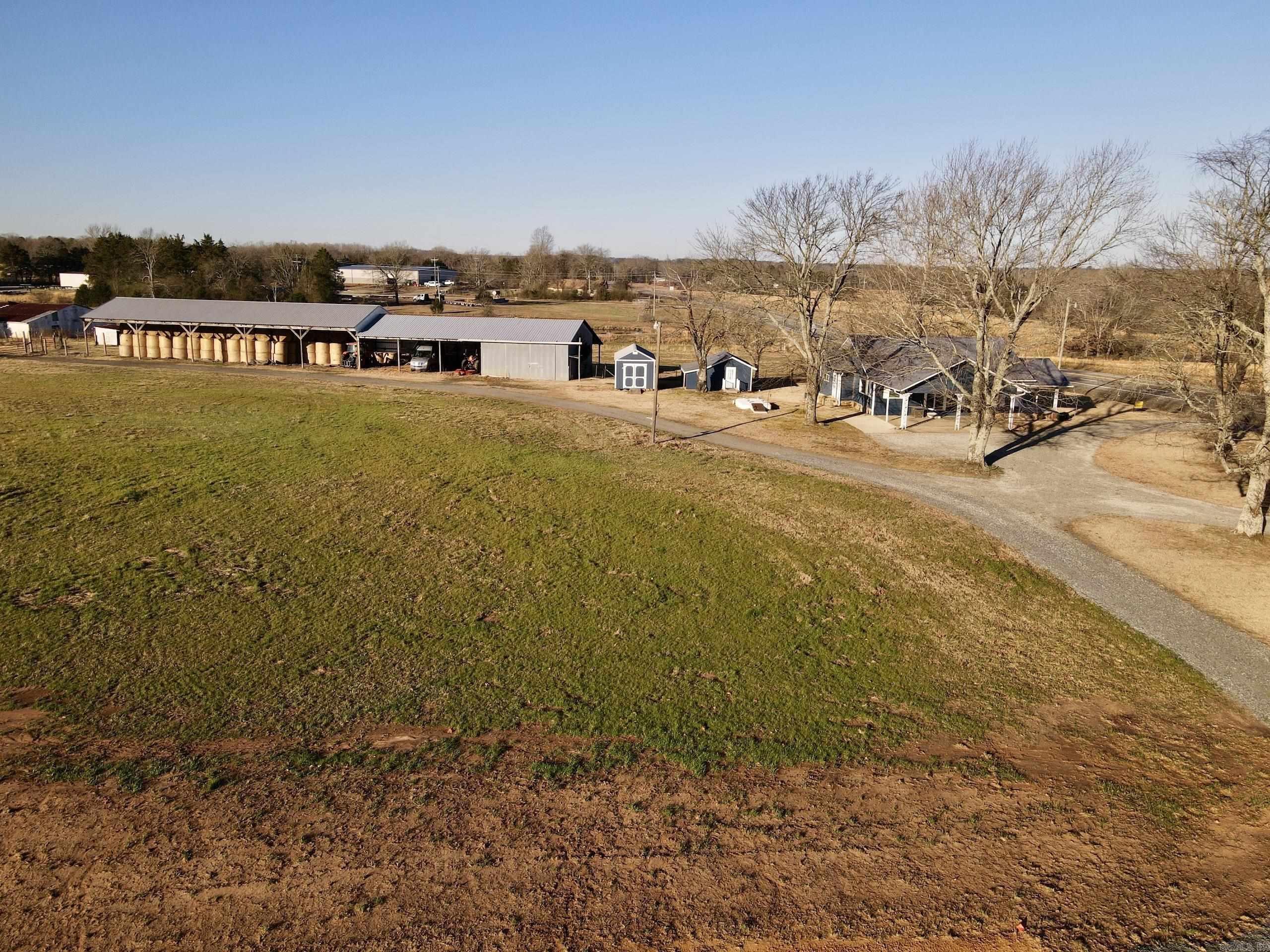 Nestled in a prime location, this charming working cattle farm offers a blend of comfort, convenience, and functionality. The property features a 1,308 sq. ft. two-bedroom, one-bath main home and a 360 sq. ft. 1 bedroom guest house complete with a full bath — perfect for visitors or potential rental income. A storm shelter is conveniently located between the two homes for added peace of mind. The farm is equipped with a 34' x 142' pole barn and a 28' x 34' shop with concrete floors, electricity (including 220 volts), water, and large sliding doors for easy equipment access. The property is fenced and cross-fenced with three spring-fed ponds ideal for watering livestock or a relaxing day of fishing. The pasture is terraced and currently used for grazing and hay production. With State Highway frontage and a second access point from a county road, this property offers excellent accessibility and potential for development. Modern utilities include electricity, rural water, natural gas, and internet. This versatile farm is ready for your next chapter — whether as a family homestead or a development opportunity!