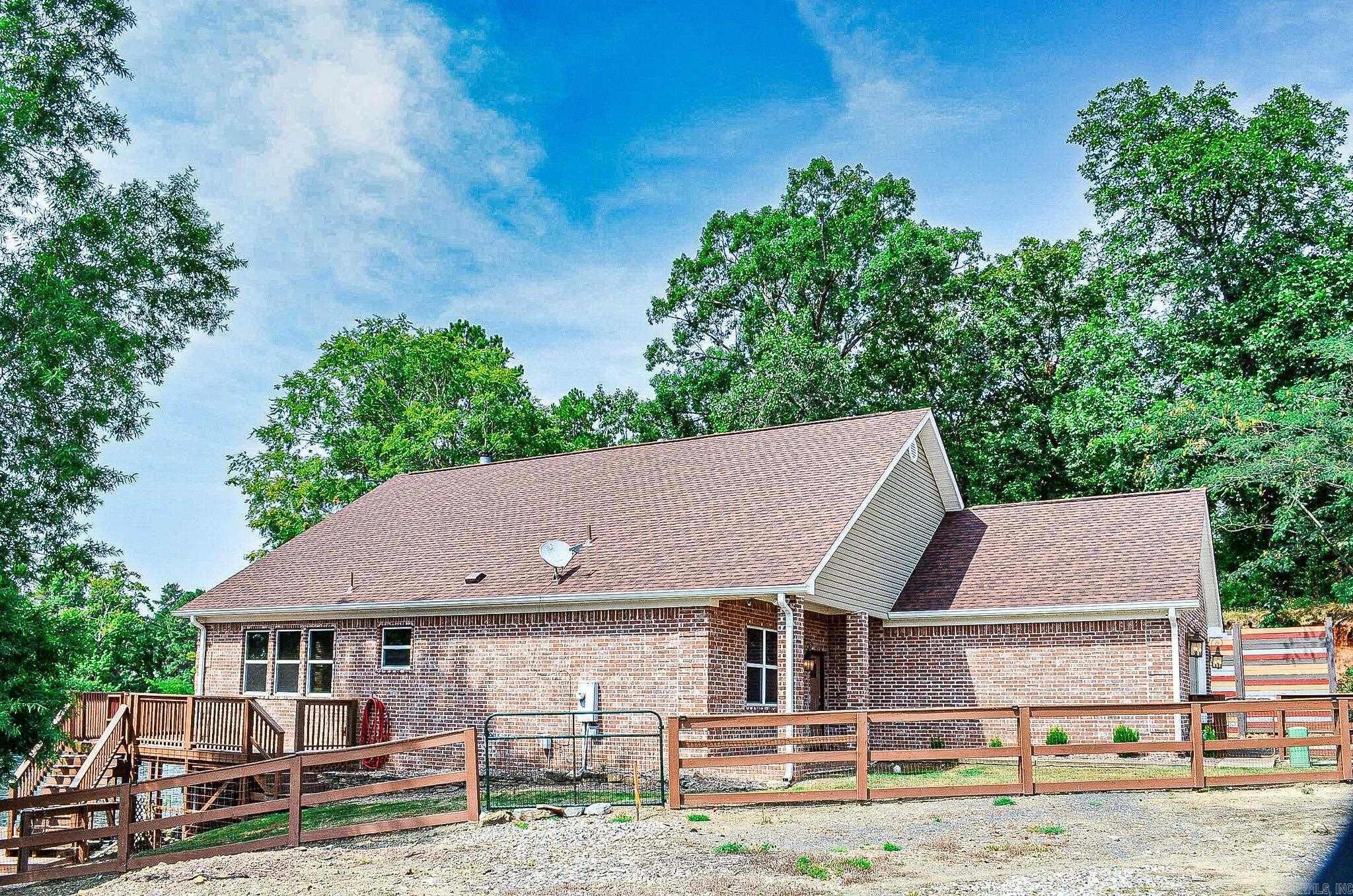 Beautiful lake front home on Lake Hamilton. This custom home has so much to offer! Beautiful hardwood vaulted ceiling in the living room and kitchen. Many interior walls are brick. Wood floors in 3 bedrooms. Large island in the kitchen for easy entertaining. Bosch appliances. Granite counters. Split bedrooms. 3 bedrooms within the main house, one private bedroom and bath with access from the deck. Kitchen, Dining, Living room and baths have tile floors. Lake front boasts a swim dock with ladder. Oversized 2 car garage. This home is currently an Airb&b. AGENTS SEE REMARKS