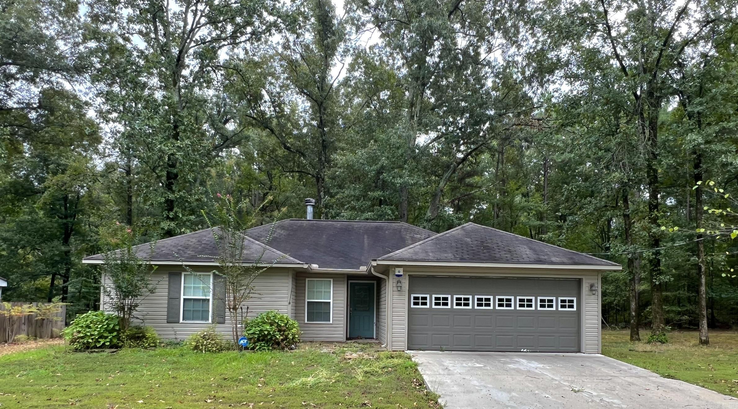This beautifully updated 3-bedroom, 2-bathroom home offers 1,329 sq ft of move-in ready comfort. Featuring new flooring, fresh paint, and stylish cosmetic upgrades throughout, the home boasts a split floor plan and a cozy wood-burning fireplace. The master bedroom includes a spacious walk-in closet, and the private laundry room adds convenience. Enjoy outdoor living with a large covered back deck, perfect for entertaining, all situated on a 3/4-acre lot. The ADT security system conveys with the property for added peace of mind.