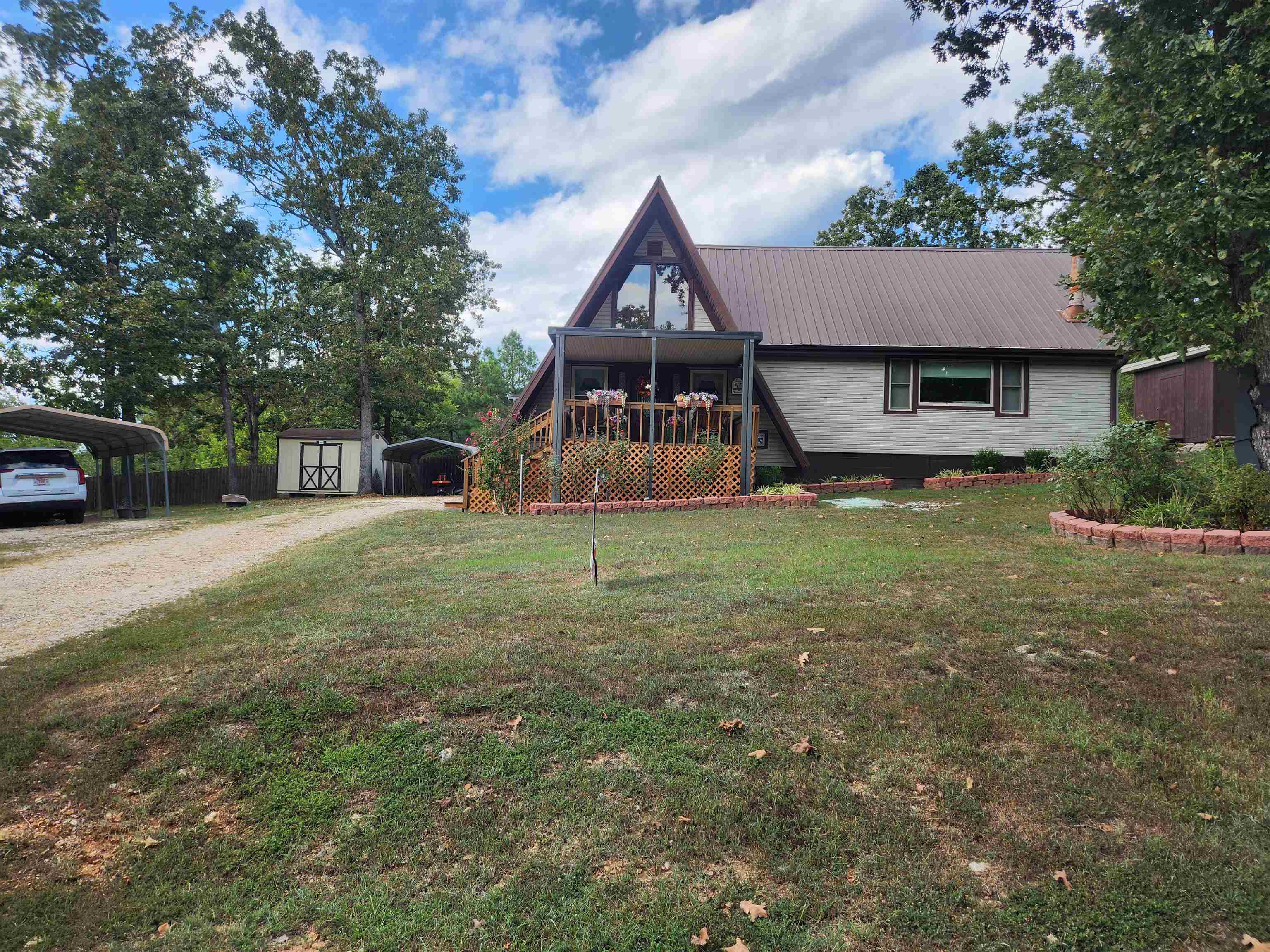 Super cute, very well-maintained Double, A-frame home with 4 bedrooms and 2 - 3/4 bathrooms. Nestled in the middle of 3 lots with lake views of Lake Mirandy. This home comes with 2 outbuildings for storage. There are 2 covered parking areas, one for cars and one for lawn maintenance equipment. There is a water softener and a huge pantry/ laundry room just off the kitchen. This home could be a perfect Vacation home or used as a VRBO. This home is conveniently located with quick access to the 4-Lane but is also secluded enough to make you feel like you're living in the country. This home can be purchased fully furnished other than the guest room, with an acceptable offer. Make an appointment to see this cutie today.