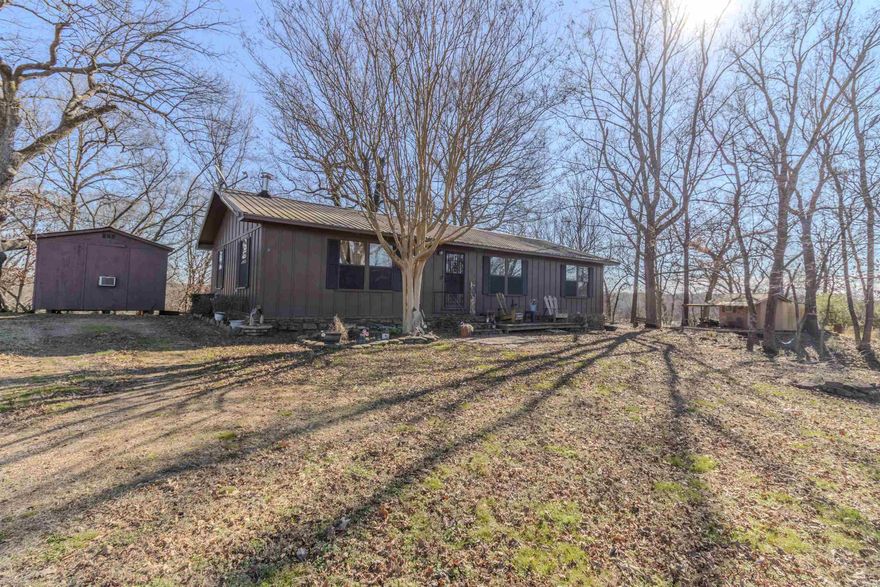 Located directly across from the University of the Ozarks sports complex, this beautifully maintained 3-bedroom, 2-bath home sitting on 1.33 acres at 700 N Hillcrest St offers convenience and versatility with proximity to University softball, baseball, tennis, soccer, and intramural events, while maintaining a peaceful residential setting. Inside features include tile flooring in the kitchen and bathrooms and LVP or LVP-style flooring throughout the living areas and bedrooms, along with a warm, rustic interior that complements the home’s character. The back deck overlooks open pasture through the trees, providing a private, country-like view. The property includes three outbuildings: a wooden, climate-controlled, partially insulated building, a wooden workshop, and a corrugated metal storage building, offering excellent space for work, hobbies, or storage. Ideal as a primary residence or investment opportunity near the university.