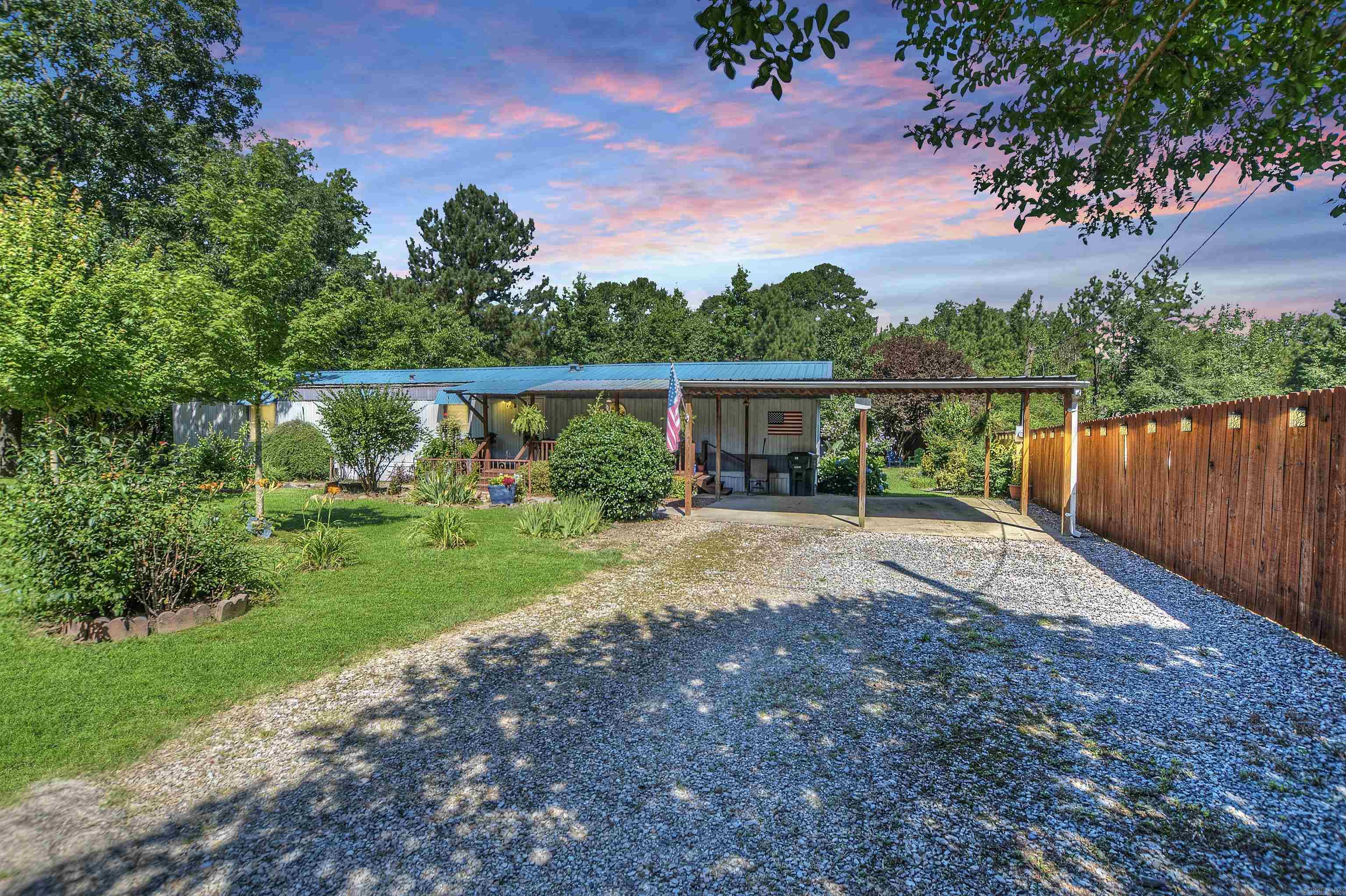 Welcome to 340 Beach Haven Road ā an adorable and well-maintained home nestled on a spacious .43-acre corner lot in beautiful Hot Springs. This charming 3-bedroom, 2-bath mobile home, built in 1996, offers 1,216 sq ft of comfortable living space with thoughtful updates and plenty of curb appeal. Step onto the inviting front rocking chair covered porch, perfect for relaxing evenings or morning coffee. Inside, youāll love the updated kitchen (renovated in 2020) featuring a new stove, refrigerator, sink, and fresh paint ā ready for your home-cooked meals. The primary bathroom was refreshed in 2024 with a brand new walk-in shower for added comfort. Outside, the fully fenced backyard (with chain link along the back and wood privacy fence on one side) is lined with curved flower beds, mature landscaping, and backs up to a wooded lot ā a private haven for garden lovers and those who appreciate nature. A small covered back porch and patio create a cozy spot for outdoor dining or entertaining, while a detached storage building adds extra convenience. Practical updates include a new A/C unit installed in 2021, plus a two-car carport for easy parking.