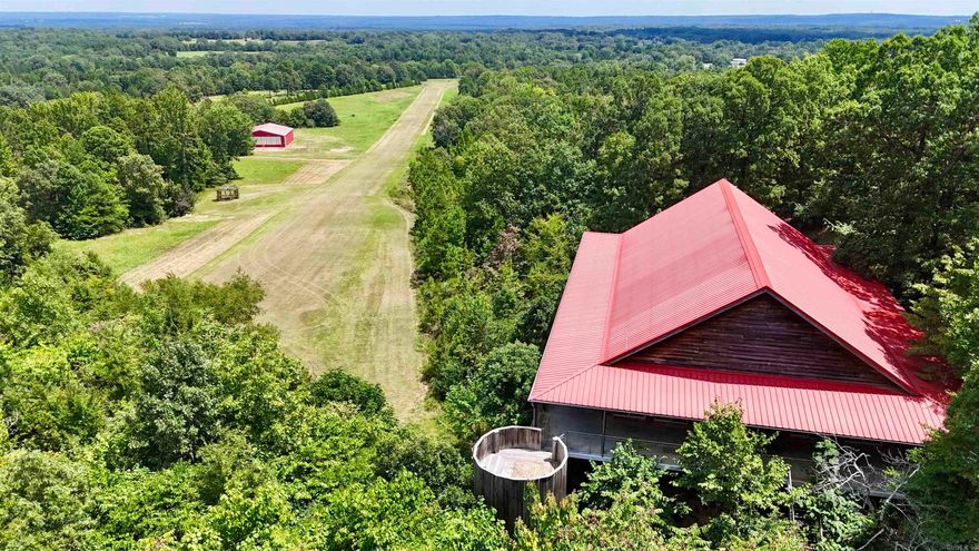 Beautiful, custom built home on elevated slab with 33.33 acres, mountain views, private airstrip, hangar/shop, 4,000 sq ft, 3 beds, 3.5 ba, in-law quarters/4th bedroom/bonus area. Grand details: picturesque views from every angle, all windows are glass sliding doors, extra wide door frames, Double sided stone fireplace, grand great room with gorgeous views, authentic tin tile ceilings throughout, vaulted/tall ceilings, spacious bedrooms, wood flooring, granite countertops, ss appliances, custom cabinets, 3700 sq ft of wrap around porches, custom made steel 12-foot water wheel, stocked pond,  2000 x 60 ft runway (FAA identifier 35 AR Sweet Springs Airport) located on property. Hangar/shop is 3,600 sq foot with half bath. The engineered structure is constructed from fabricated steel including floor, porch, walls, and roof. Outside is covered in 1 inch cypress siding. The runway and Hangar can be converted into anything you desire.  Perfect private residence or could be a Venue/business of your choosing. Request a copy of the Seller info sheet & Video/drone tour. Do not miss this "Once in a Lifetime Opportunity" to own this unique property.