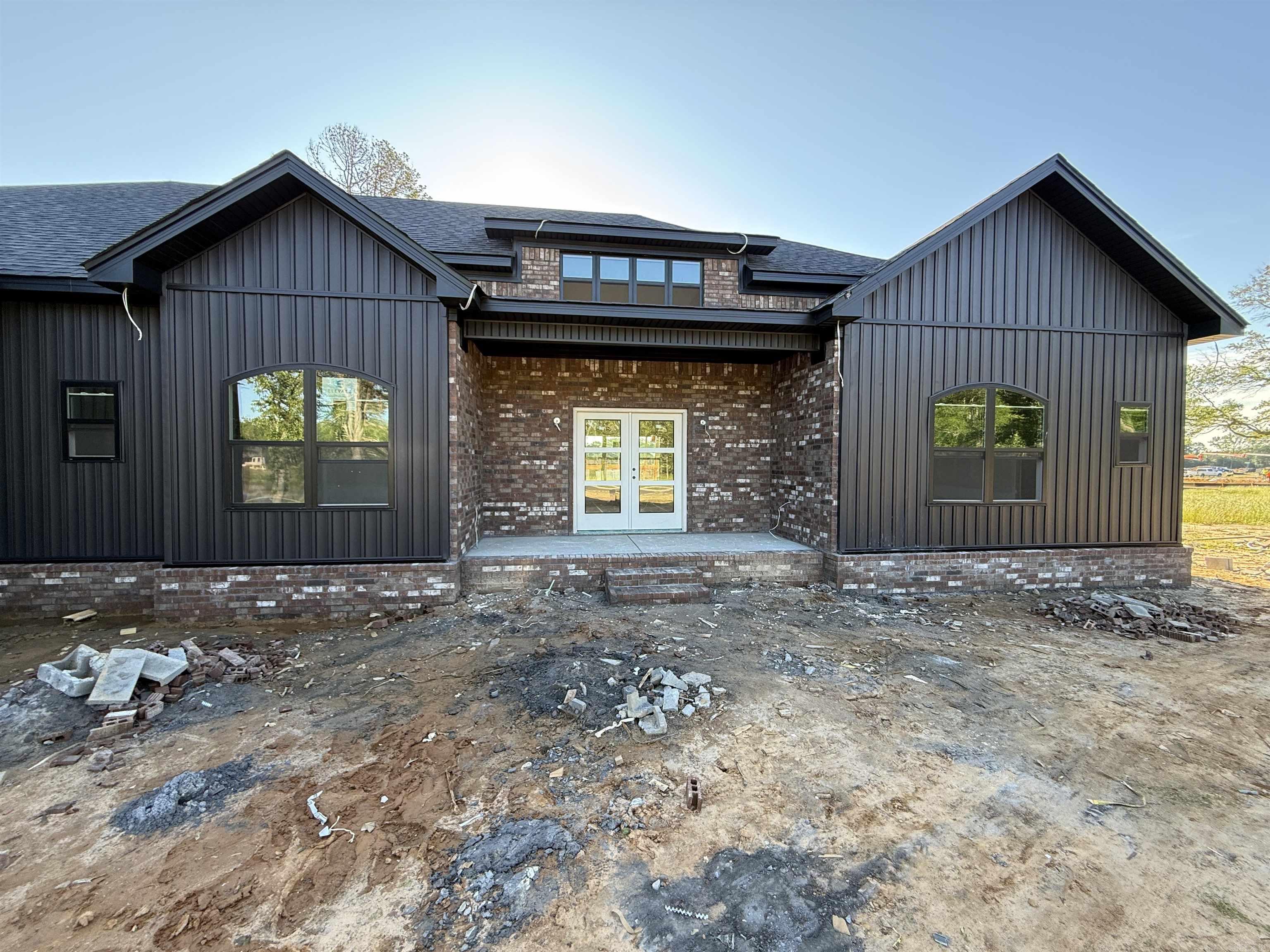 Step inside this stunning black board-and-batten home that blends modern design with thoughtful functionality. Currently in the dry stage of construction, this home features tall ceilings and an open-concept layout that centers around a spacious kitchen with a large island, adjoining dining area, and a convenient butlerās pantry. The living room offers a cozy electric fireplace framed by elegant arched built-ins. Designed with flexibility in mind, this home can be configured as either a 4-bedroom or a 3-bedroom with a dedicated officeāall with generously sized closets. The guest bathroom includes a double vanity, shower/tub combo, and extra storage space. The primary suite is truly a retreat, boasting a freestanding tub with a walk-in shower behind it, double vanities with knee space, and dual āhis, her & herā closetsāeach outfitted with built-in drawers and shoe shelves. Enjoy the ease of a walk-through laundry room that connects directly to the primary suite, plus a functional mudroom and half bath for guests. The oversized garage provides plenty of additional storage and parking space. Donāt miss your opportunity to own this thoughtfully designed new construction home!!!!!