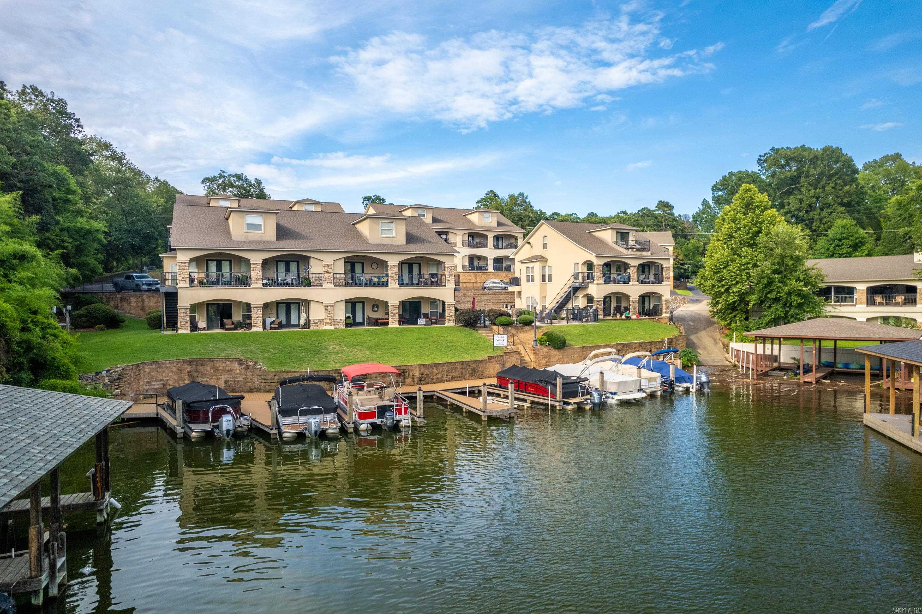 Discover the perfect blend of tranquility and convenience in this beautifully maintained 3-bedroom, 3-bath lakefront condo nestled in a peaceful cove just off the main channel of Lake Hamilton. Located in one of Hot Springs’ most sought-after areas, this property offers its own boat slip, serene water views, and a quiet, family-friendly environment ideal for both full-time living and weekend getaways. Step inside the living space filled with natural light, featuring a spacious kitchen, generous bedrooms, and a private balcony perfect for enjoying morning coffee or evening sunsets over the water. The upstairs touts plenty of living space for any amount of guests. Whether you’re entertaining or relaxing, you’ll love the calm setting with no through-traffic and minimal boat wake, making it ideal for swimming, kayaking, or simply unwinding lakeside. This is lake life at its most peaceful—close to everything, yet a world away. Don’t miss your chance to own a slice of paradise on Lake Hamilton.