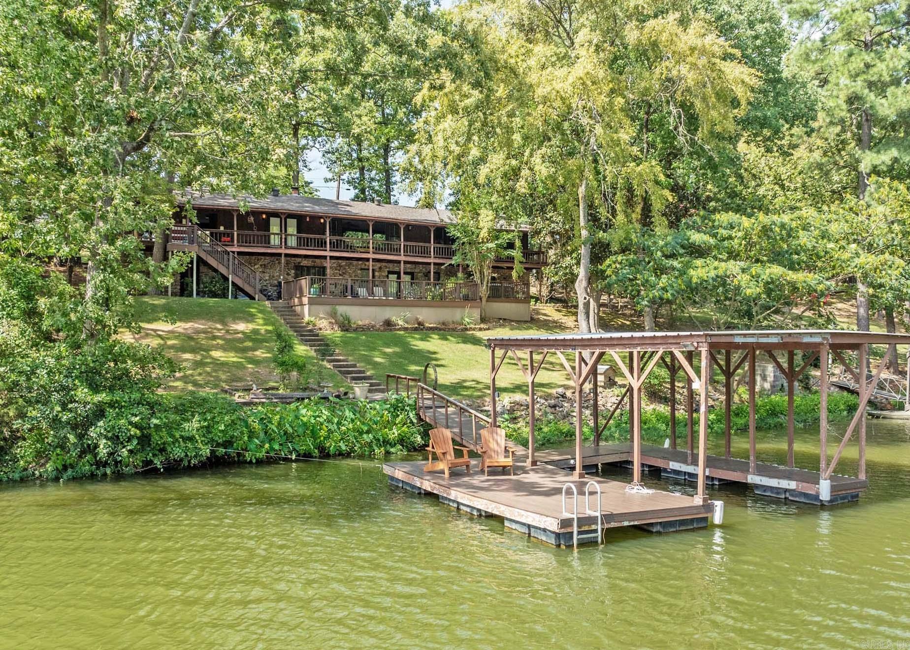 PRIVATE LAKE OASIS ..... your stress and worries will quickly melt away in this awesome lake home just off the main channel of Lake Hamilton! A warm and relaxing interior featuring 4 bdrms, 3 baths and a home theater and a huge outdoor living space with covered deck and patio areas - covered boat dock! This home has been a great rental investment and will also make a great full-time home!
