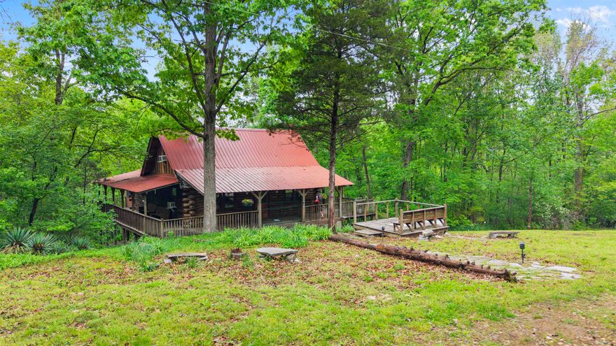 Welcome to 709 Jones Road in Timbo, Arkansas — a fully furnished authentic log cabin tucked away down a quiet dirt road and literally nestled in the mountains of Stone County, where the property stretches across the clear waters of Roasting Ear Creek. This is the kind of place people dream about when they picture a true Ozark escape. Inside, the cabin offers a main-level bedroom plus a two-sided loft that comfortably holds three king beds in total. An enclosed, heated and cooled sleeping porch wraps around the back, creating a year-round retreat surrounded by nature. The kitchen blends rustic charm with modern appliances and conveniences, making everyday living or guest stays effortless. A stand-up crawlspace adds security and practicality, while a hidden ground-level porch gives you one more place to relax, listen to the creek, and enjoy the quiet. Whether you’re looking for a nightly rental investment, a weekend getaway, or a full-time residence, this property delivers privacy, character, and natural beauty — all just minutes from the music, shops, and energy of beautiful Mountain View, Arkansas. All furnishings to be included with acceptable offer.