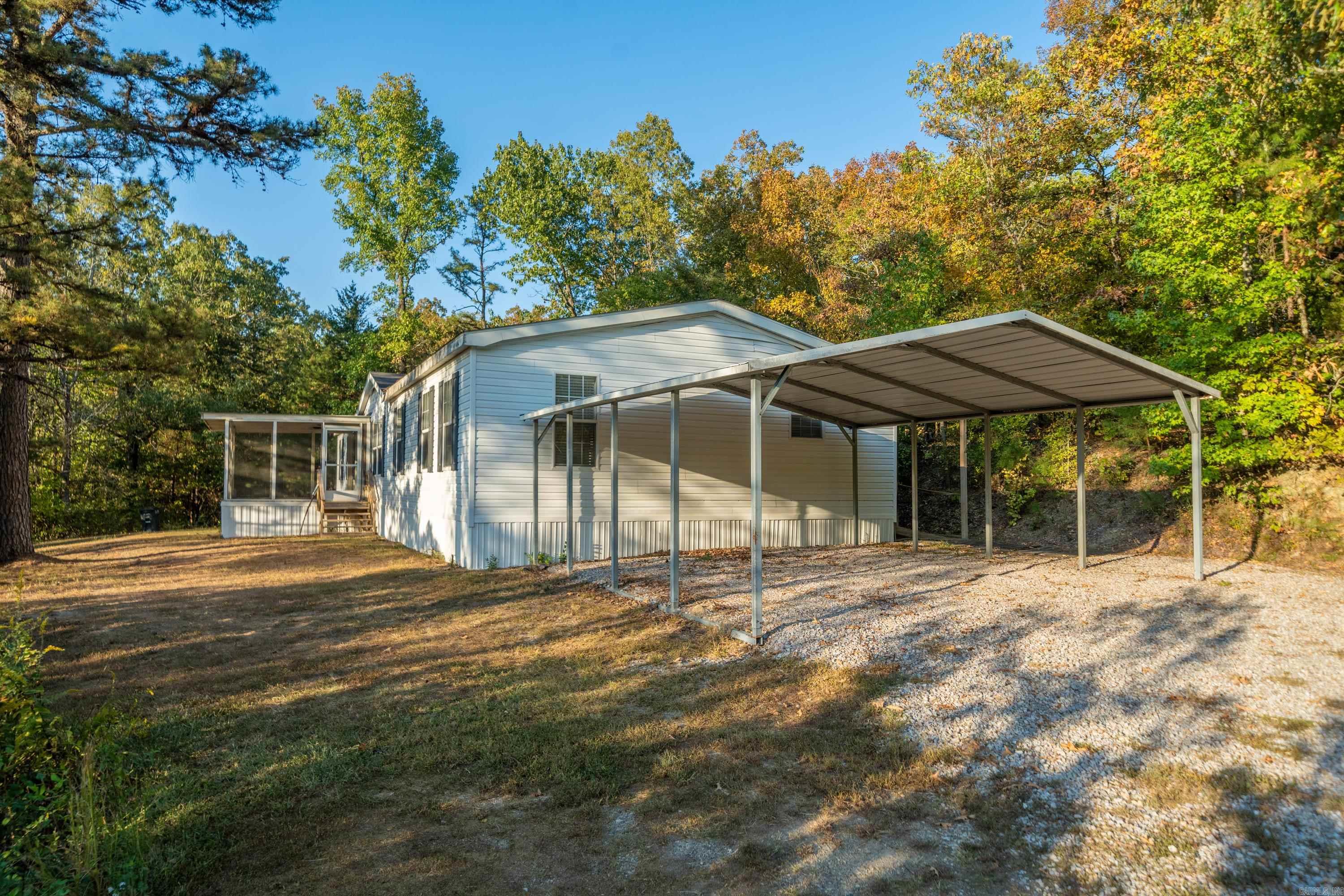 *Home on 3+ acres in The Heart of Mount Ida!* Enjoy the tranquility of the wooded surroundings as you are welcomed by the long private driveway and a small pond, giving this property a peaceful, country-like feel. Experience the best of both worlds with this 4-bedroom, 2-bath home, situated on 3.36+/- acres just inside Mount Ida city limits - known as the "Quartz Crystal Capital of the World". The expansive 2,050+ sqft. double-wide offers ample living space, featuring a large living room with an electric fireplace and a second living room/den with a wood-burning fireplace. The master bedroom sets apart with an ensuite bathroom with dual vanities, spa tub, separate walk-in shower, and large walk in closet. This home also features a two-car carport - adding extra convenience to this serene and private property.